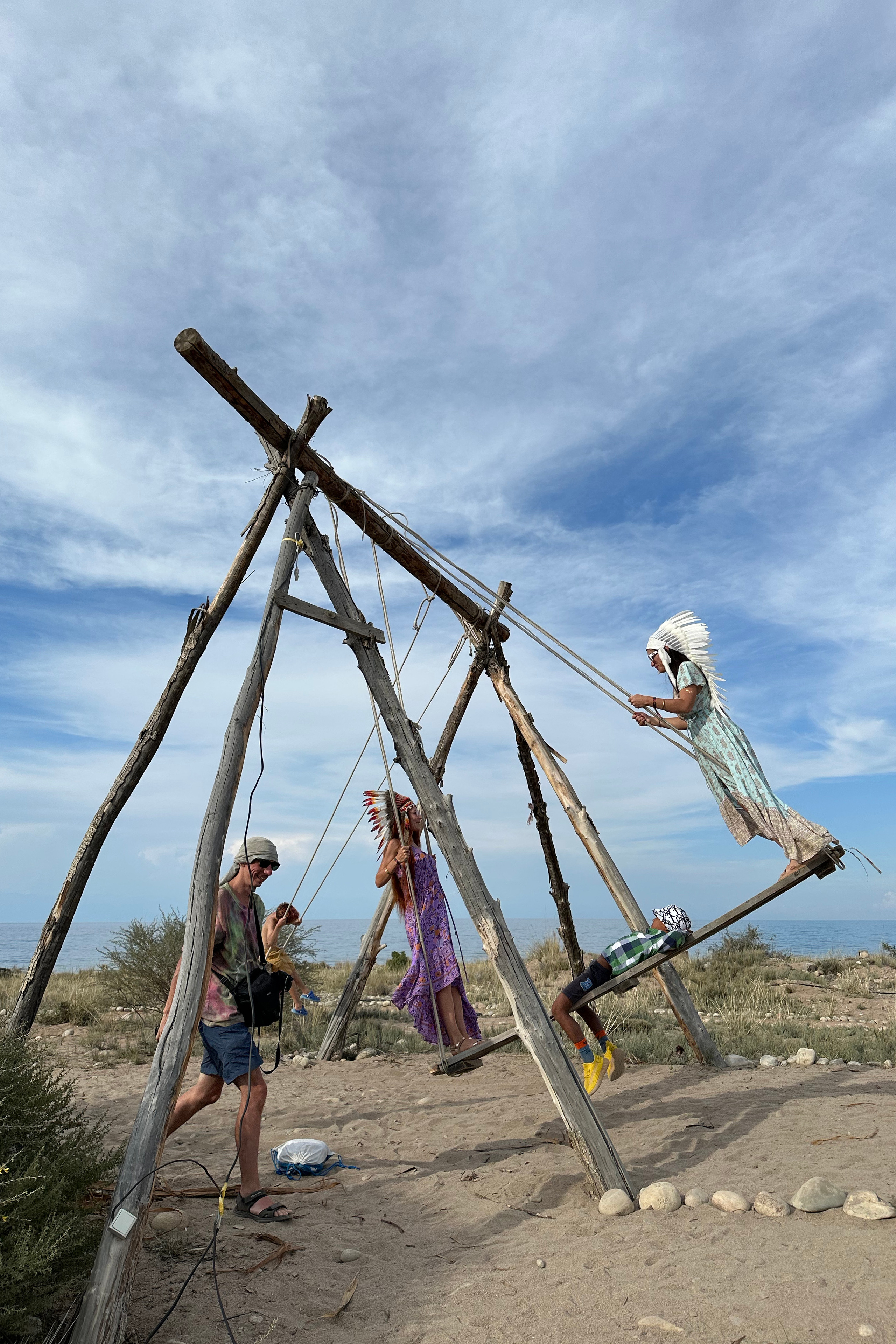 Девушки в костюмах индейцев катаются на большой качеле 