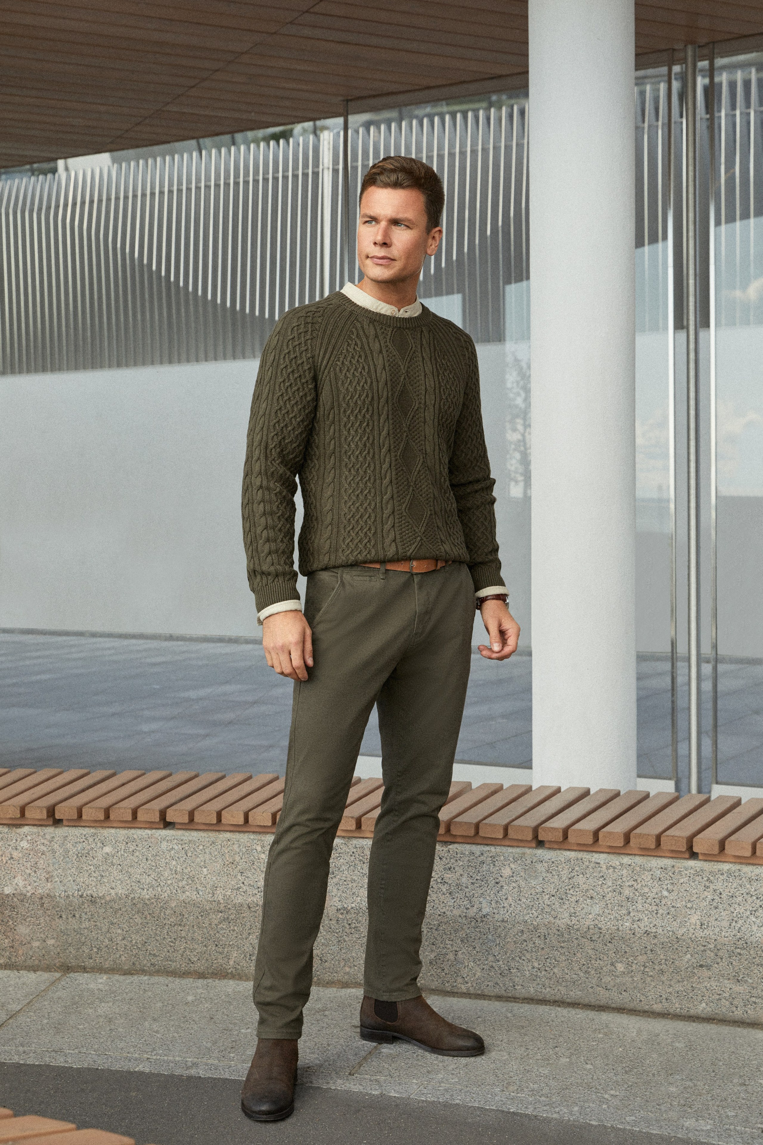 Мужчина модель в зеленых штанах и свитере