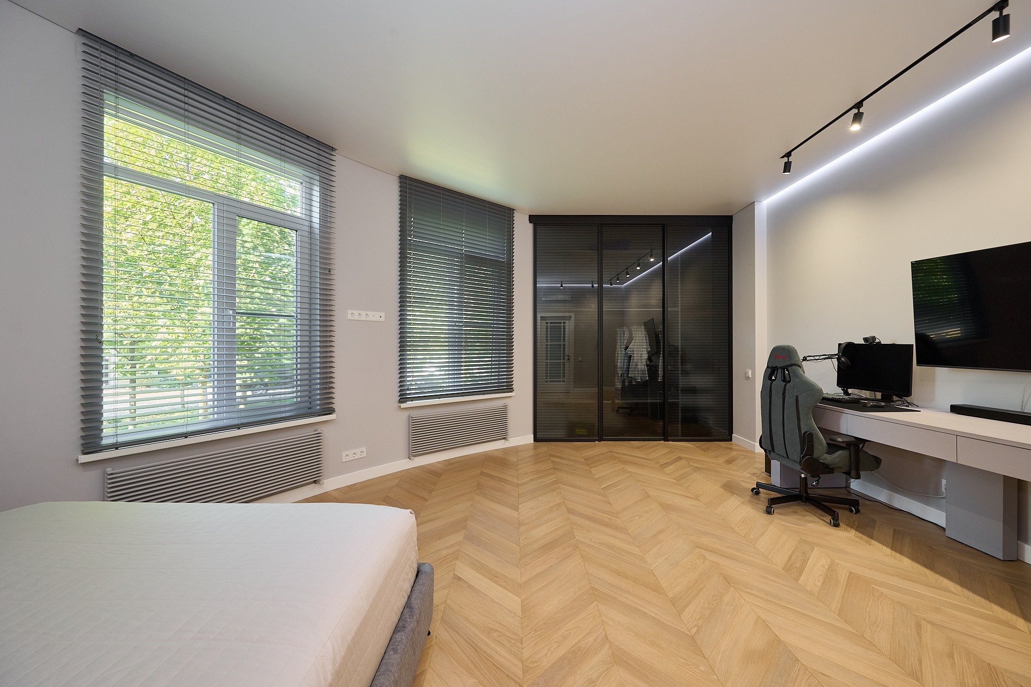 комната светлые стены белая кровать светлый стол с полками черный стеклянный шкаф телевизор 