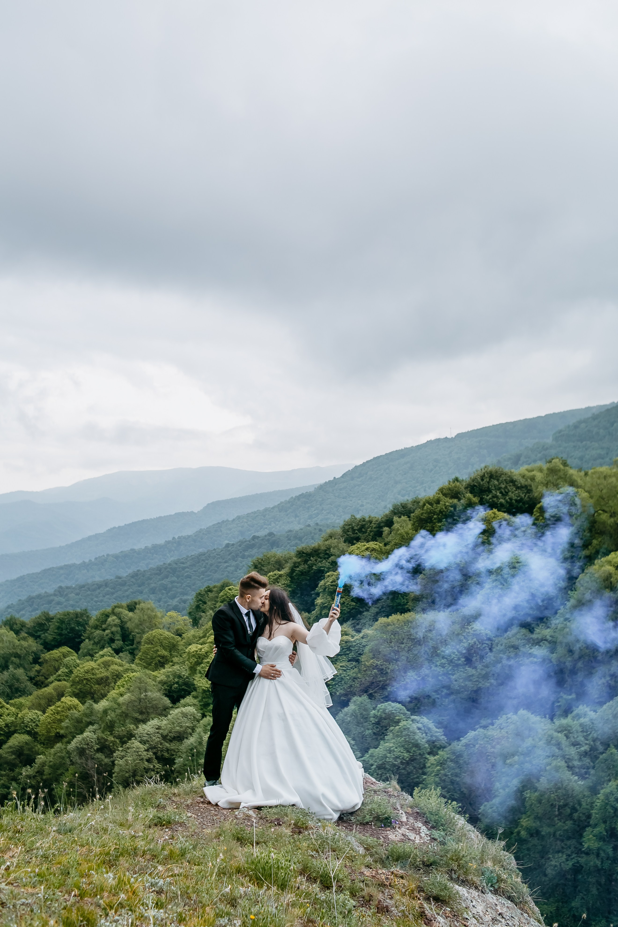 Пара, имеющая романтический пикник на высокогорной поляне, окруженная великолепными горными пейзажами