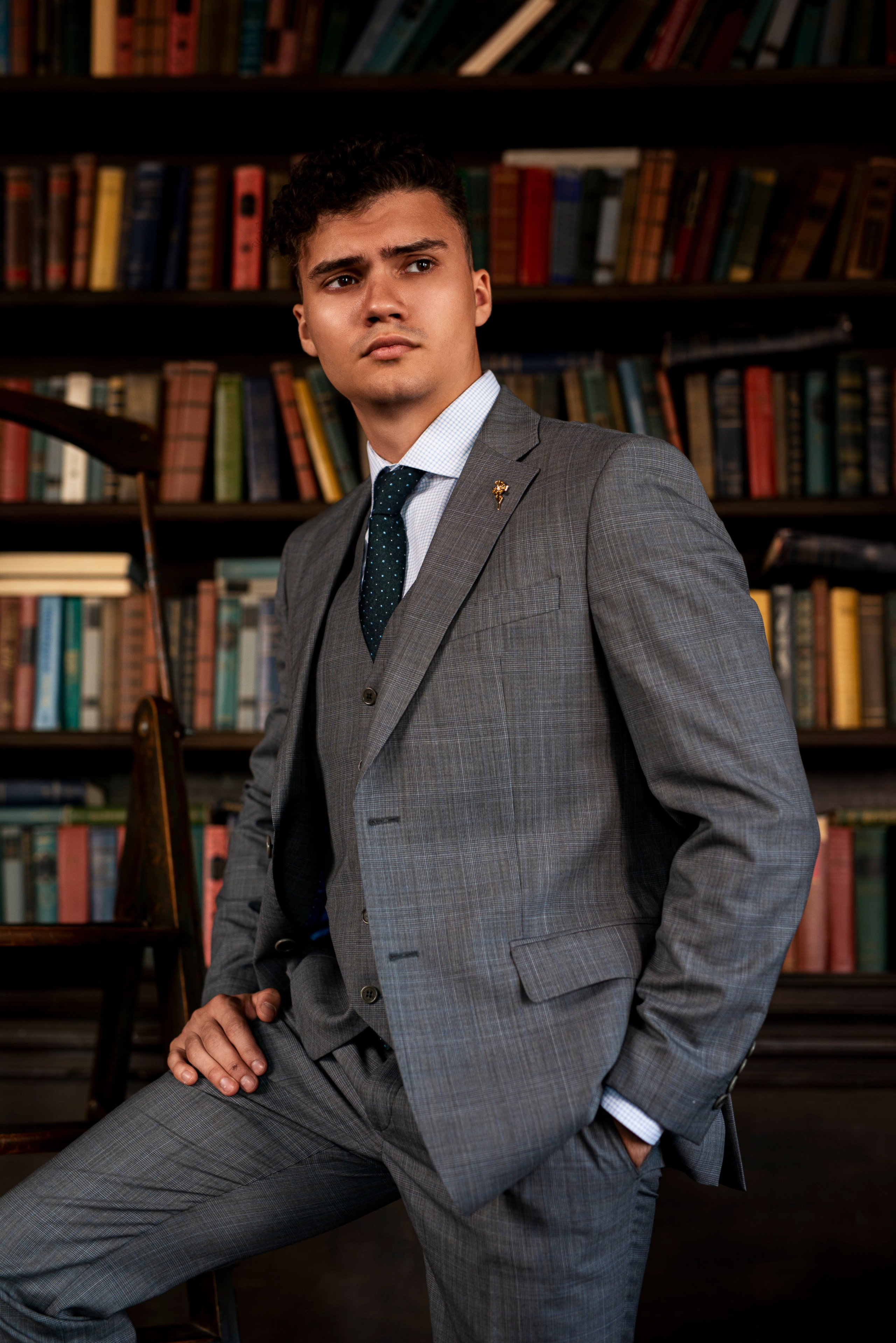 Мужчина в костюме сел на угол кресла во время съёмки