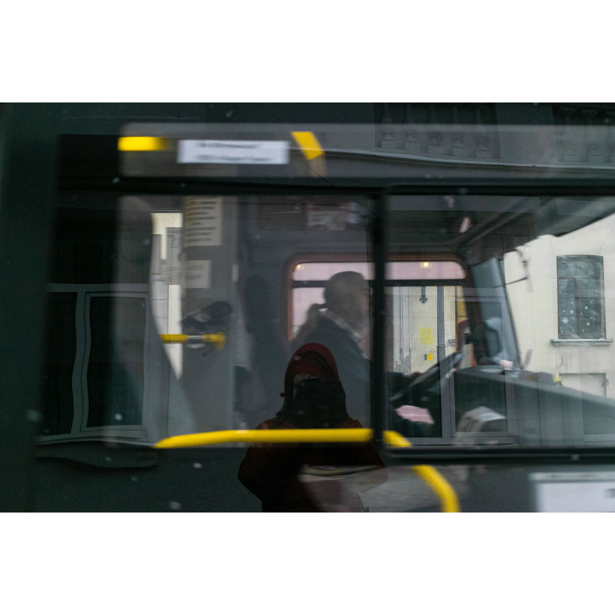 Водитель автобуса и желтые поручни.