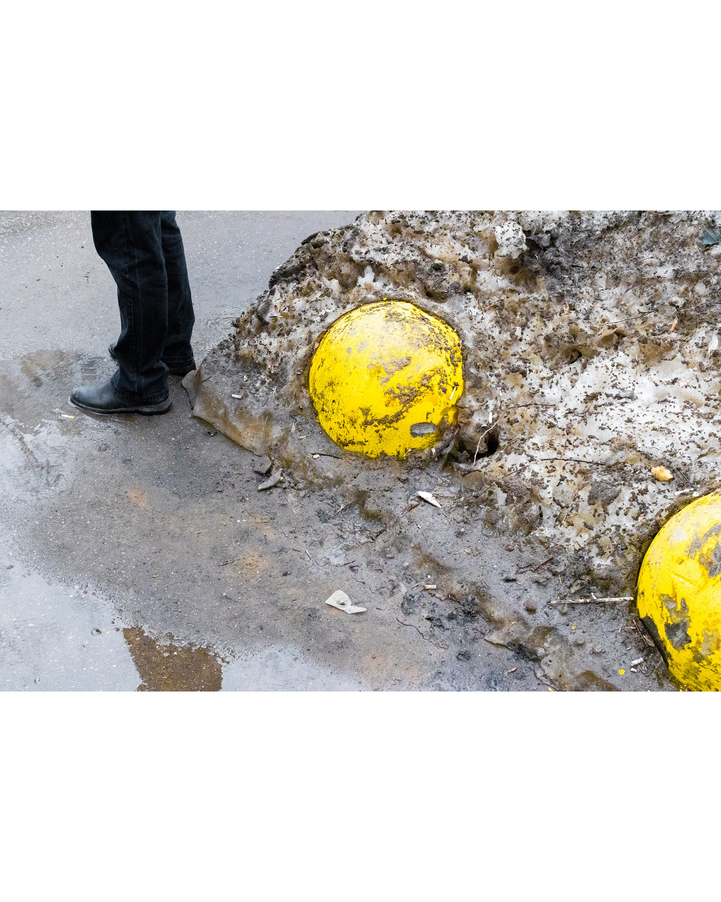 Человек стоит рядом с желтыми оградительными сферами.