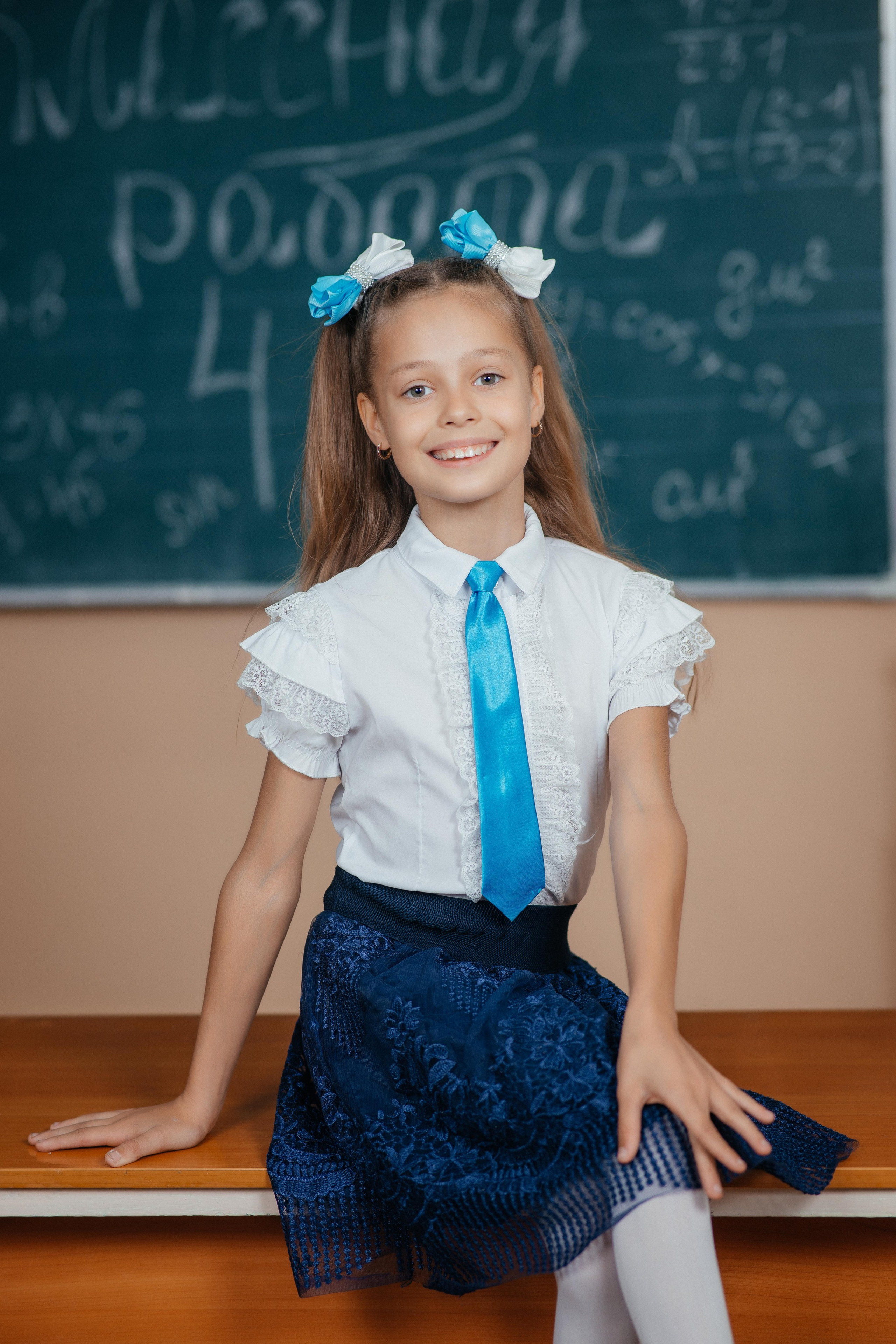 Выпускница в школьной форме на фото съемке выпускного альбома для четвертого класса