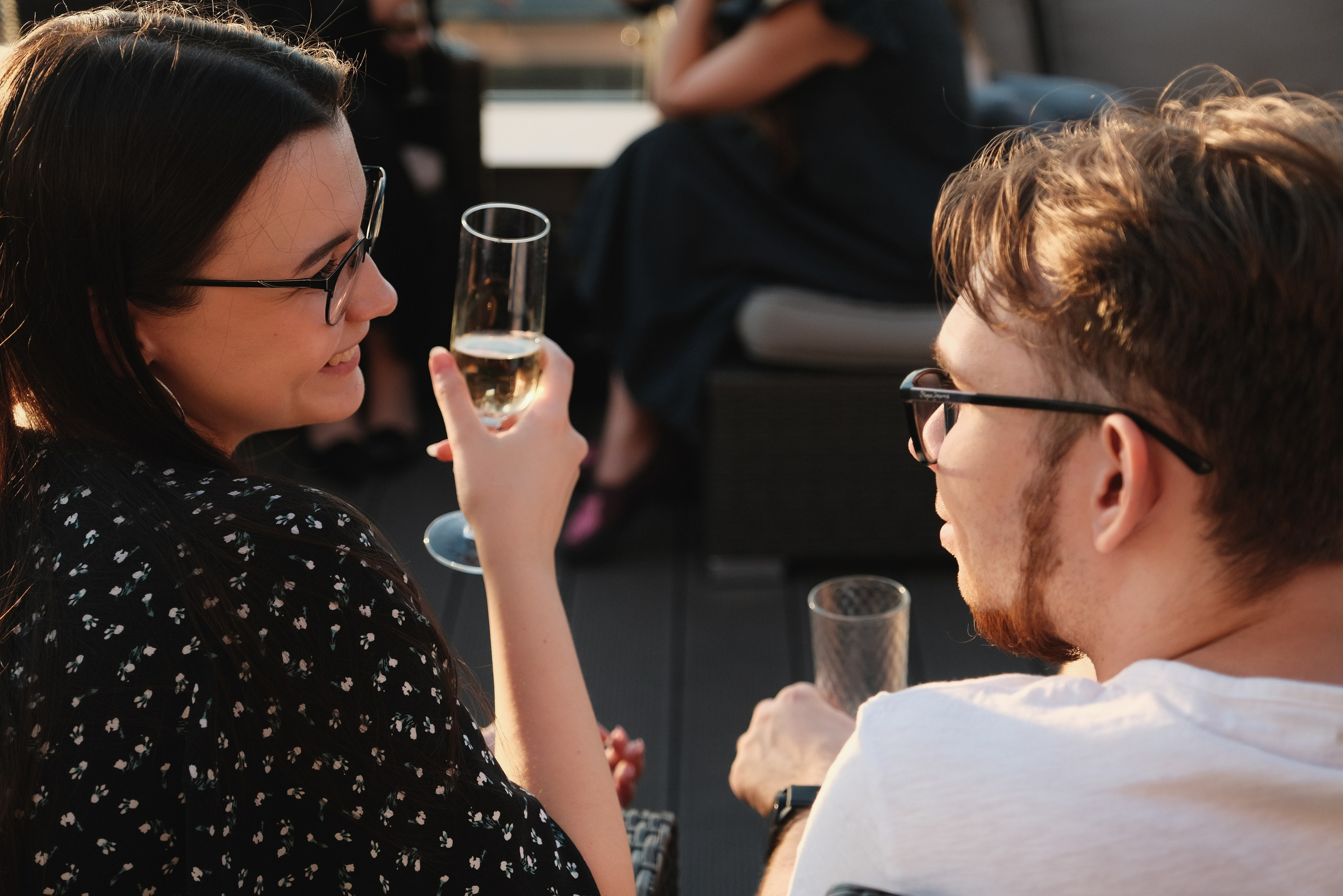 Парень и девушка на корпоративной вечеринке в Москве. Общение с бокалом вина в руках.