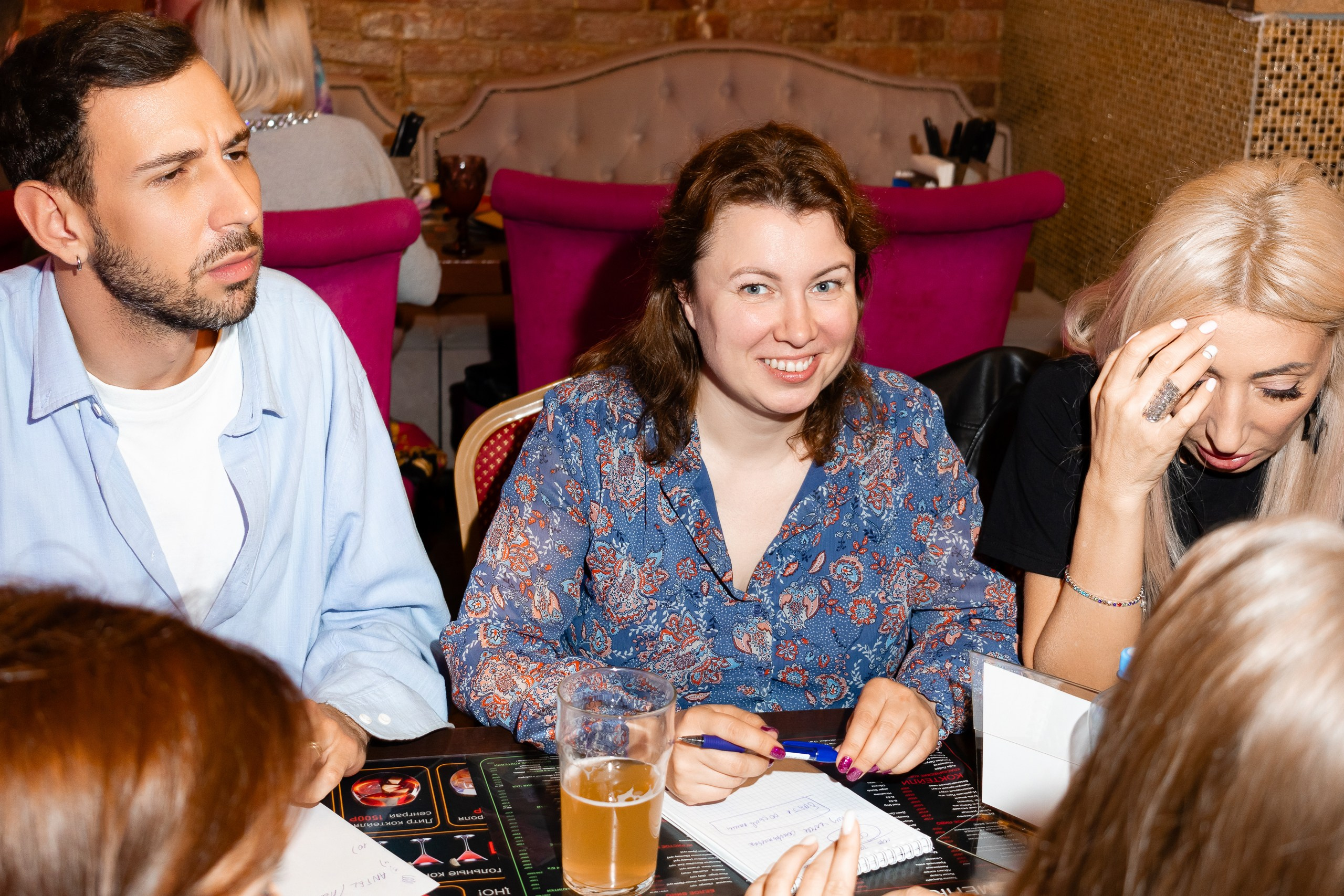 Команда игроков викторины думает над ответом, а одна девушка позирует фотографу