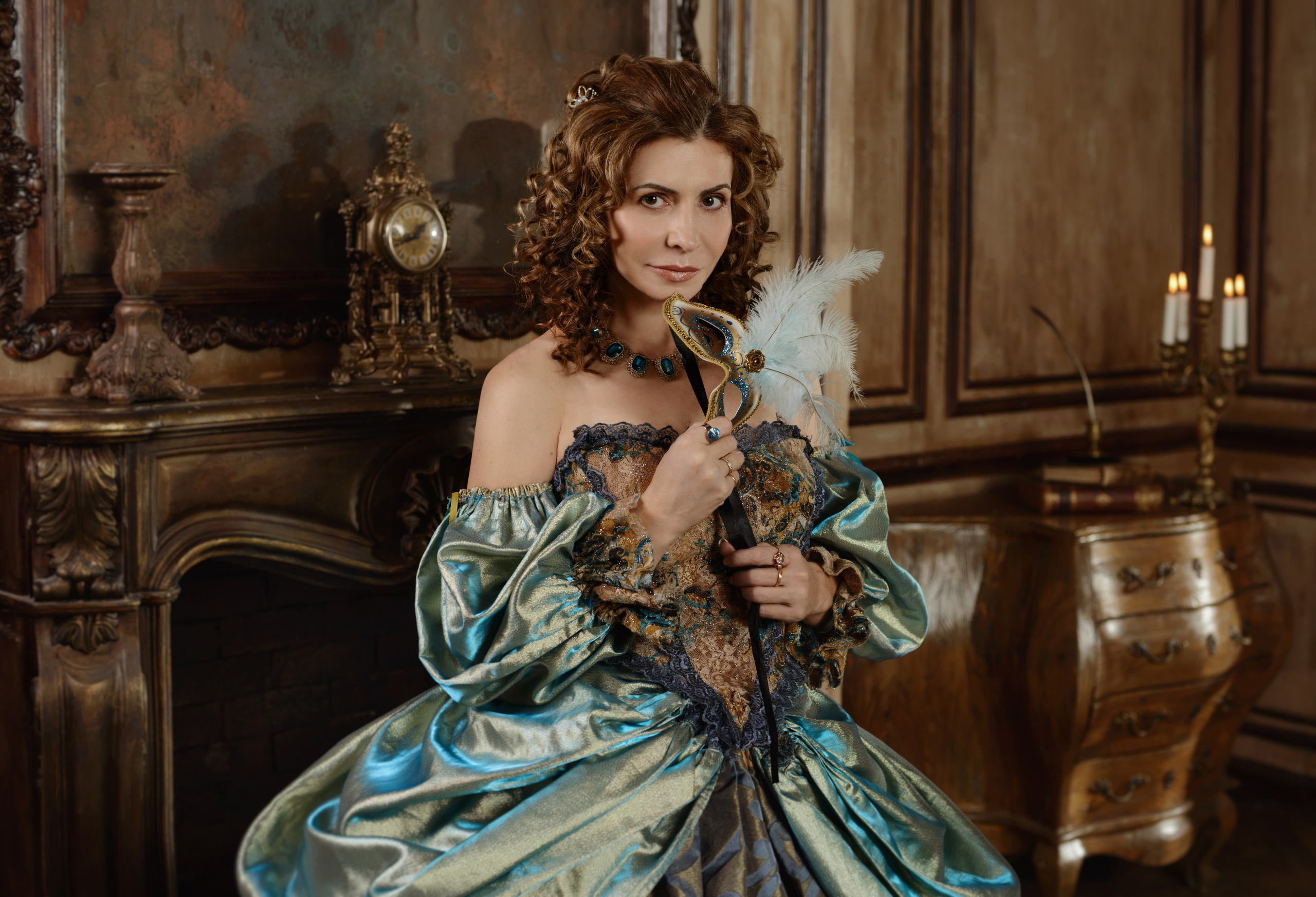 Историческая фотосессия по мотивам романа Алексадра Дюма "Три мушкетера". Женщина в лиловом с золотым платье и прическе XVII века позирует в гостинной с маской в руке