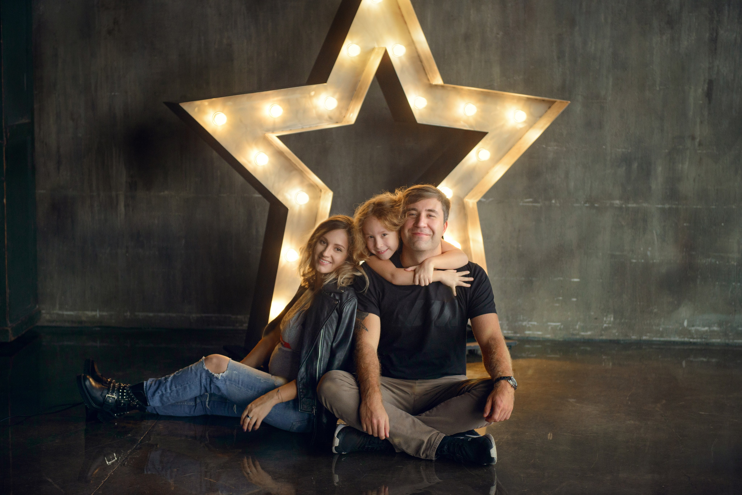Family photo shoot with a pregnant woman in a loft studio, rock and roll style