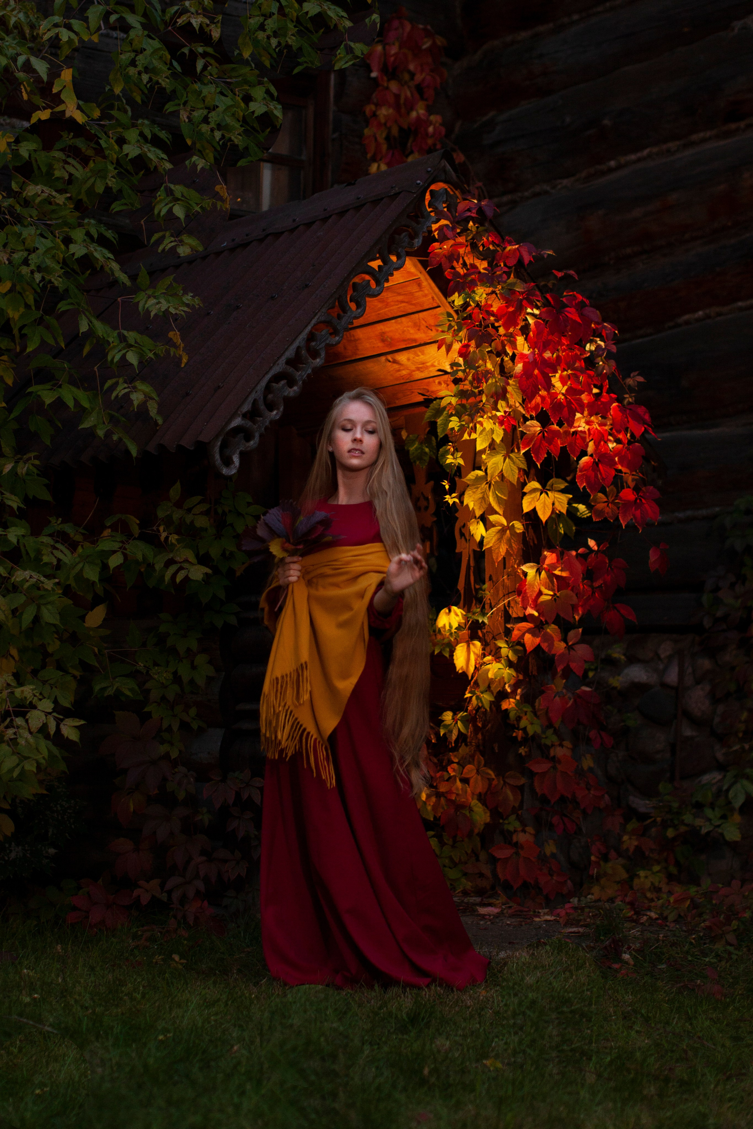 молодая симпатичная девушка фотографируется возле домика осенью. фотосессия для девушки