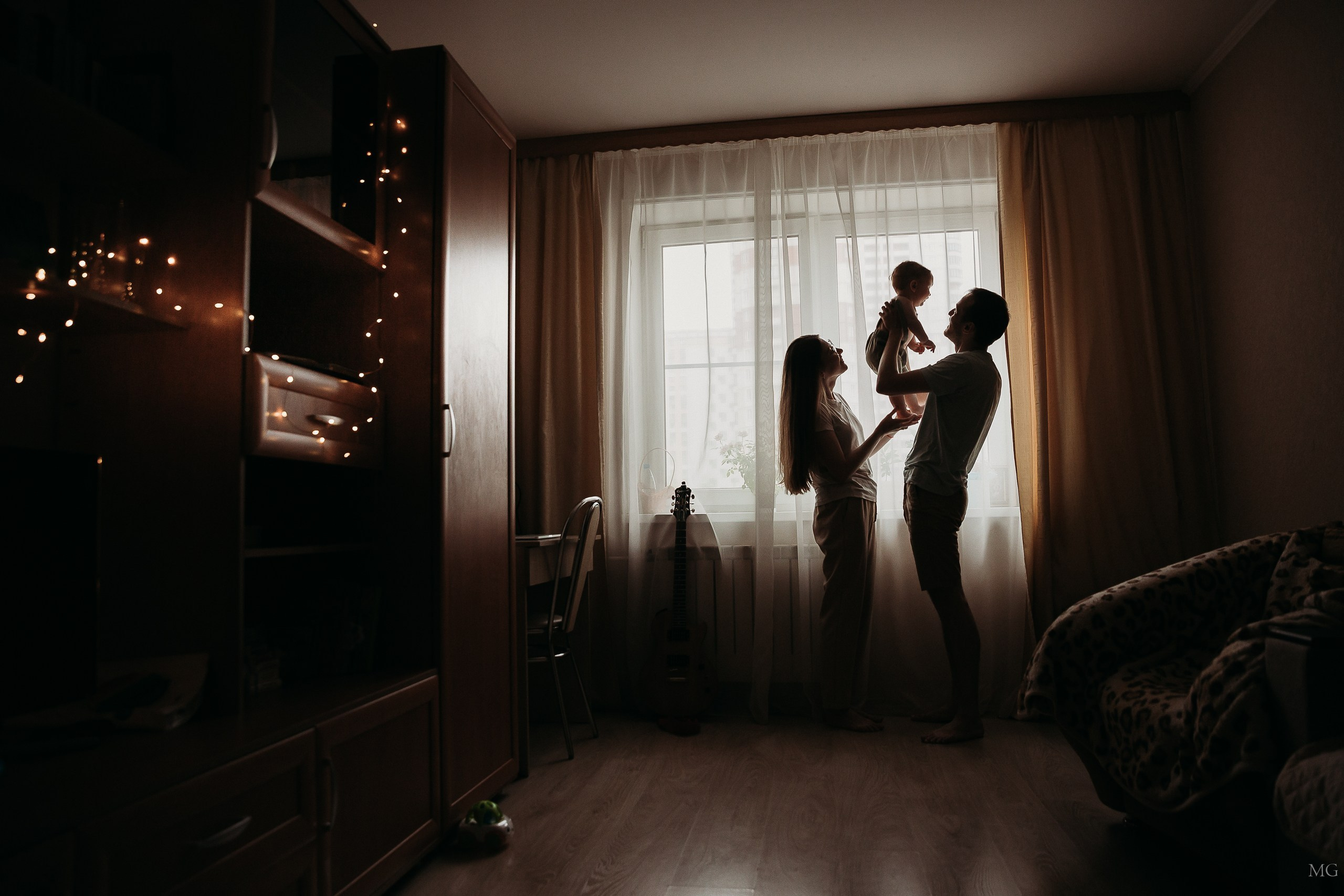 силуэты мамы папы и малыша в квартире у окна