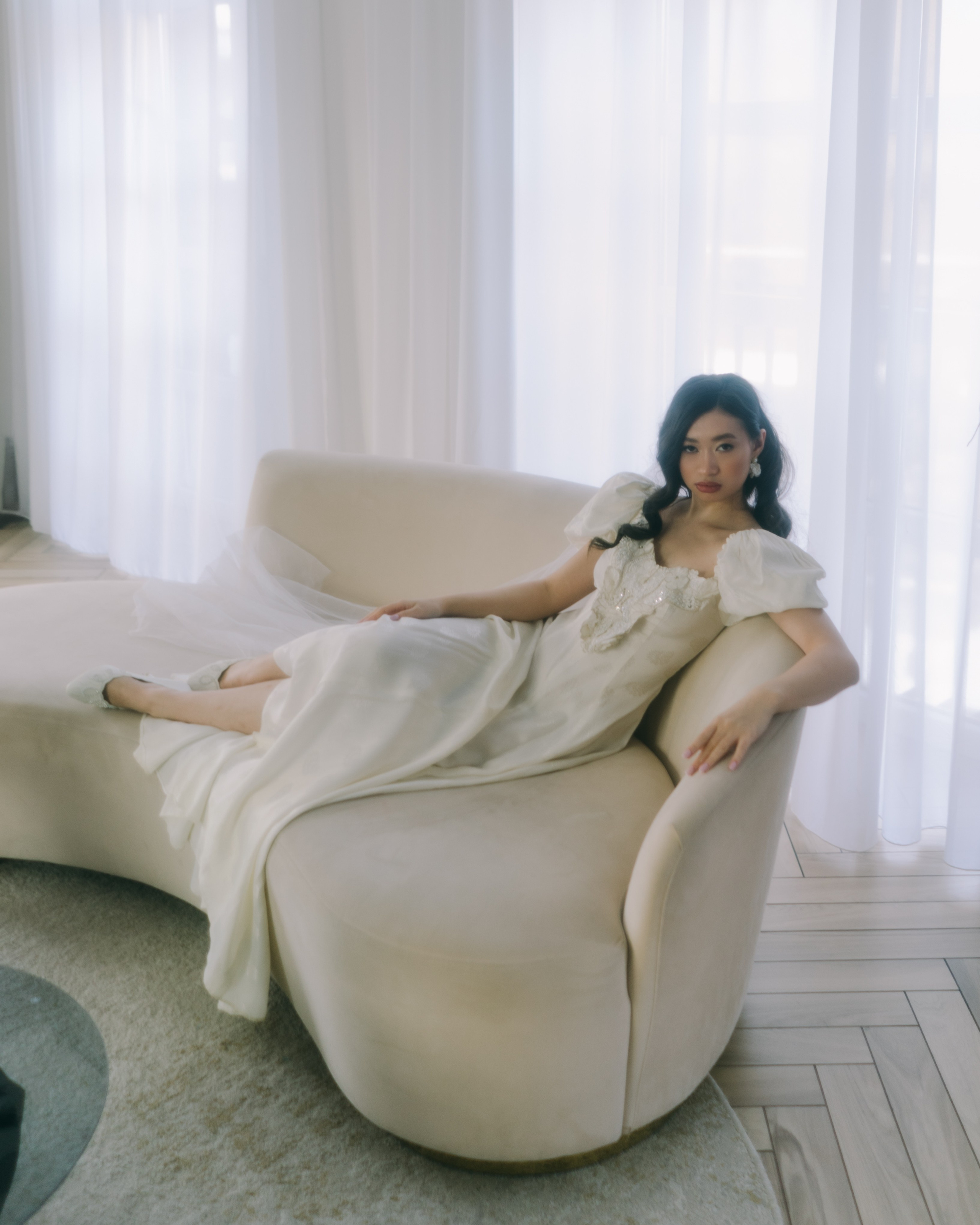 Невеста лежит в кресле у окна, editorial bridal фотосессия в светлом интерьере