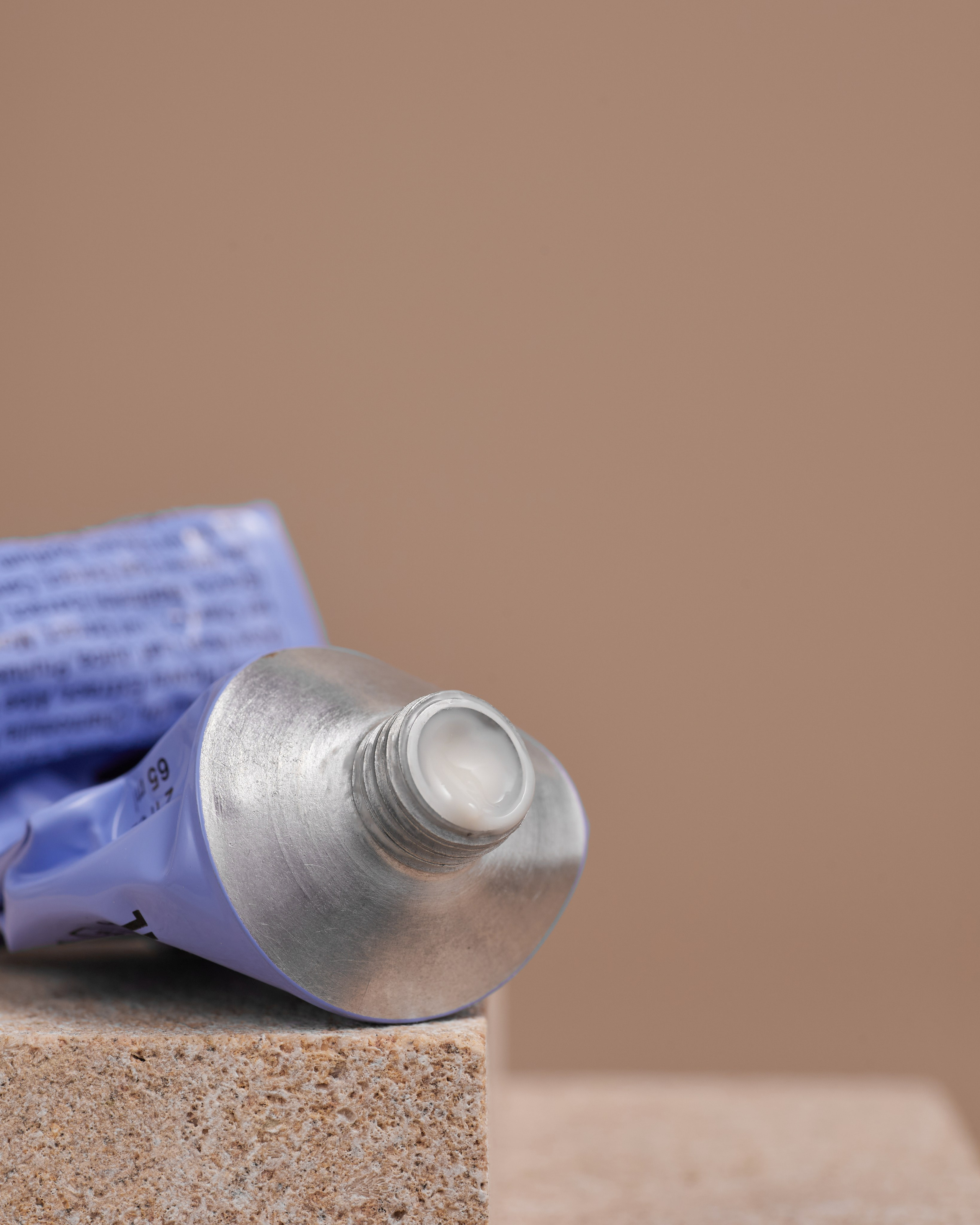 Стильное имиджевое фото уходовой косметики (тюбик и крем) на камнях, снятое для рекламной кампании.