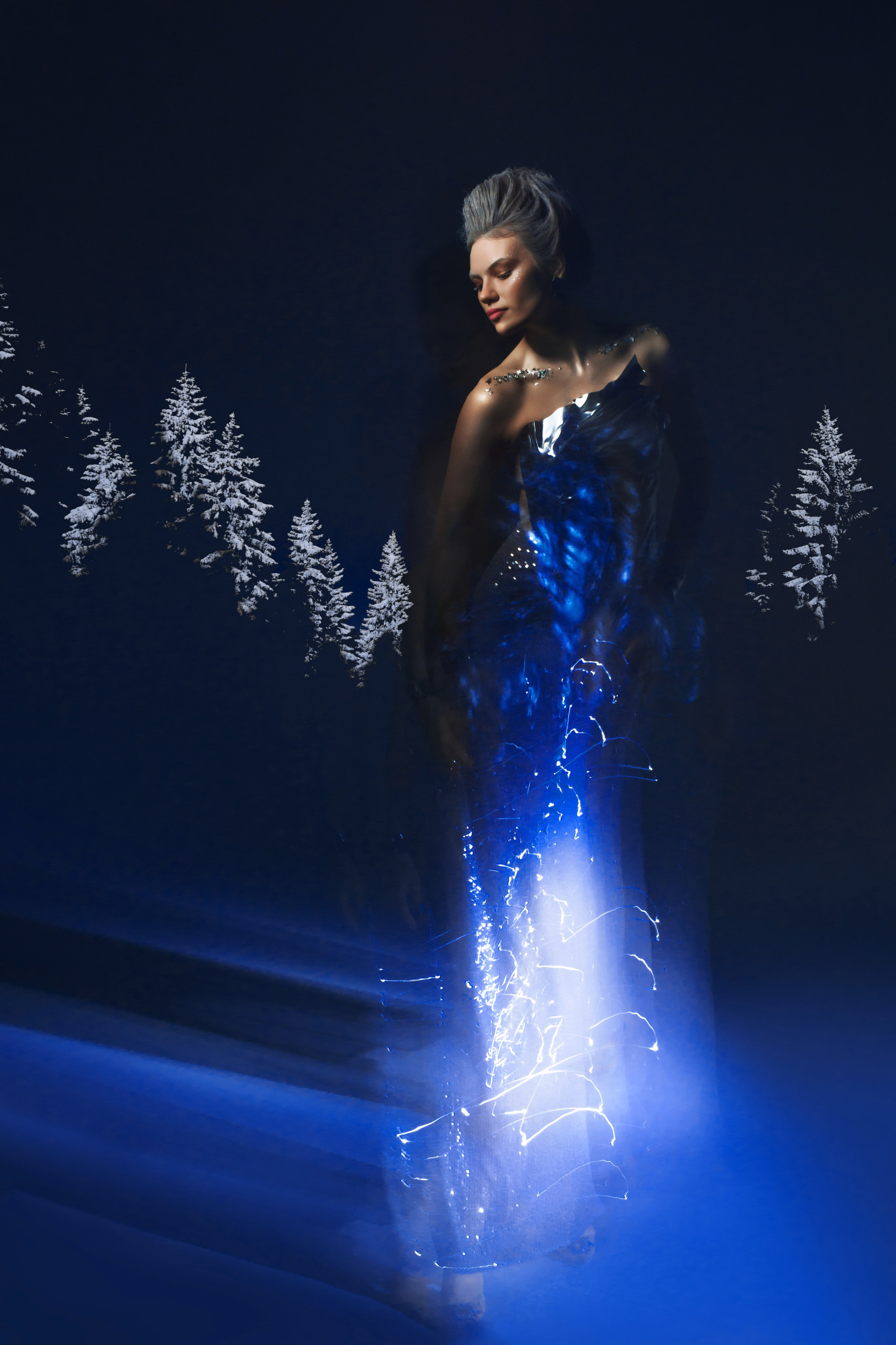 В этой фотосессии мы видим девушку, сияющую под смешанным светом, словно сама воплощение зимы. Она - госпожа снега и льда, манящая своей величественностью