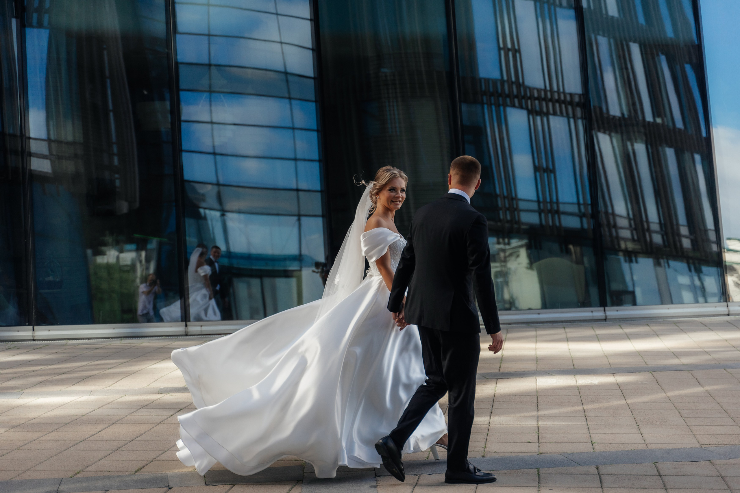 жених и невеста идут около здания Банка Санкт-Петербург