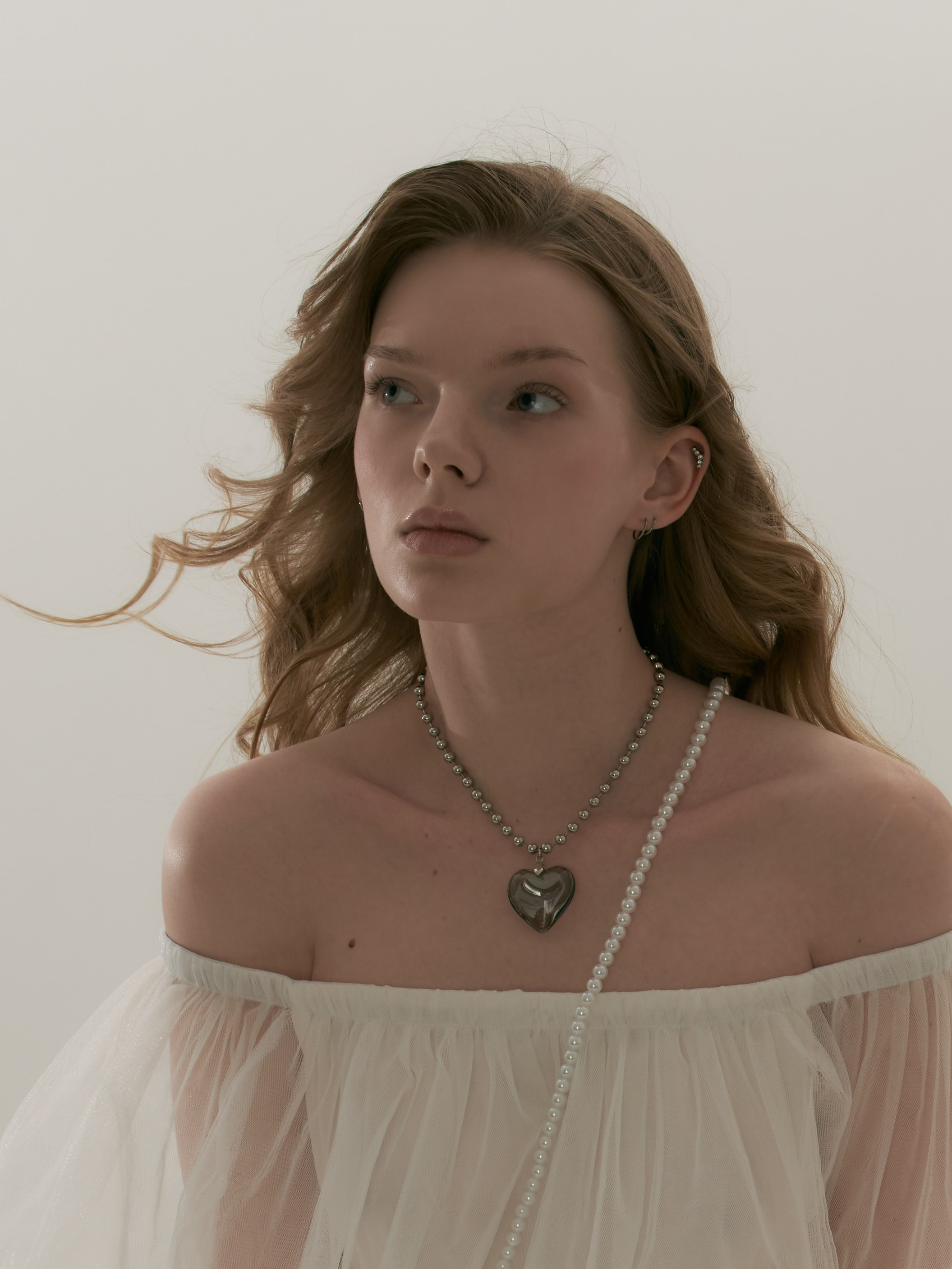 Молодая красивая девушка с длинными волнистыми волосами в лёгком фатиновом платье