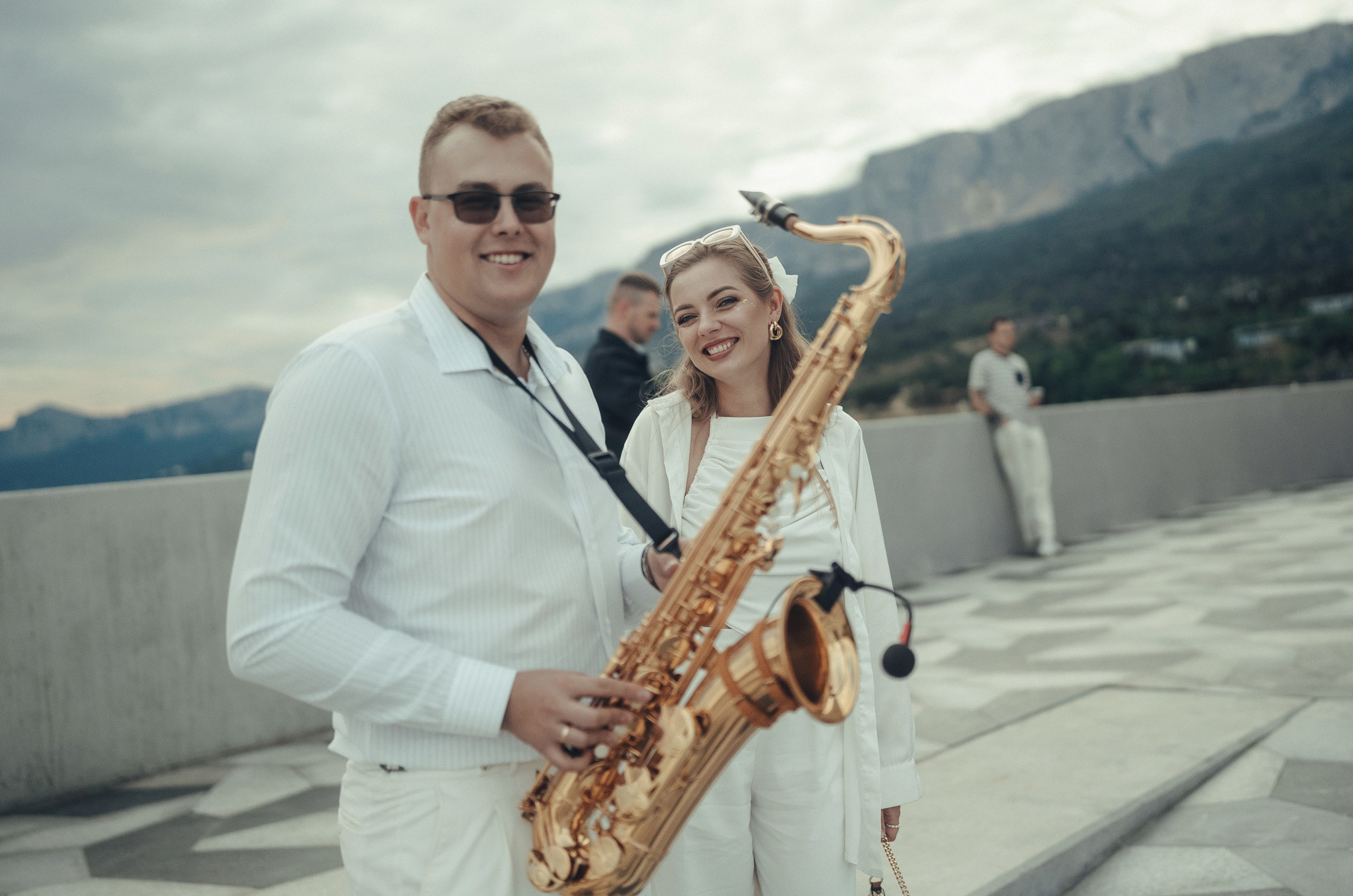 Репортажная фотосессия в Крыму: саксофонист улыбается и смотрит в камеру.
