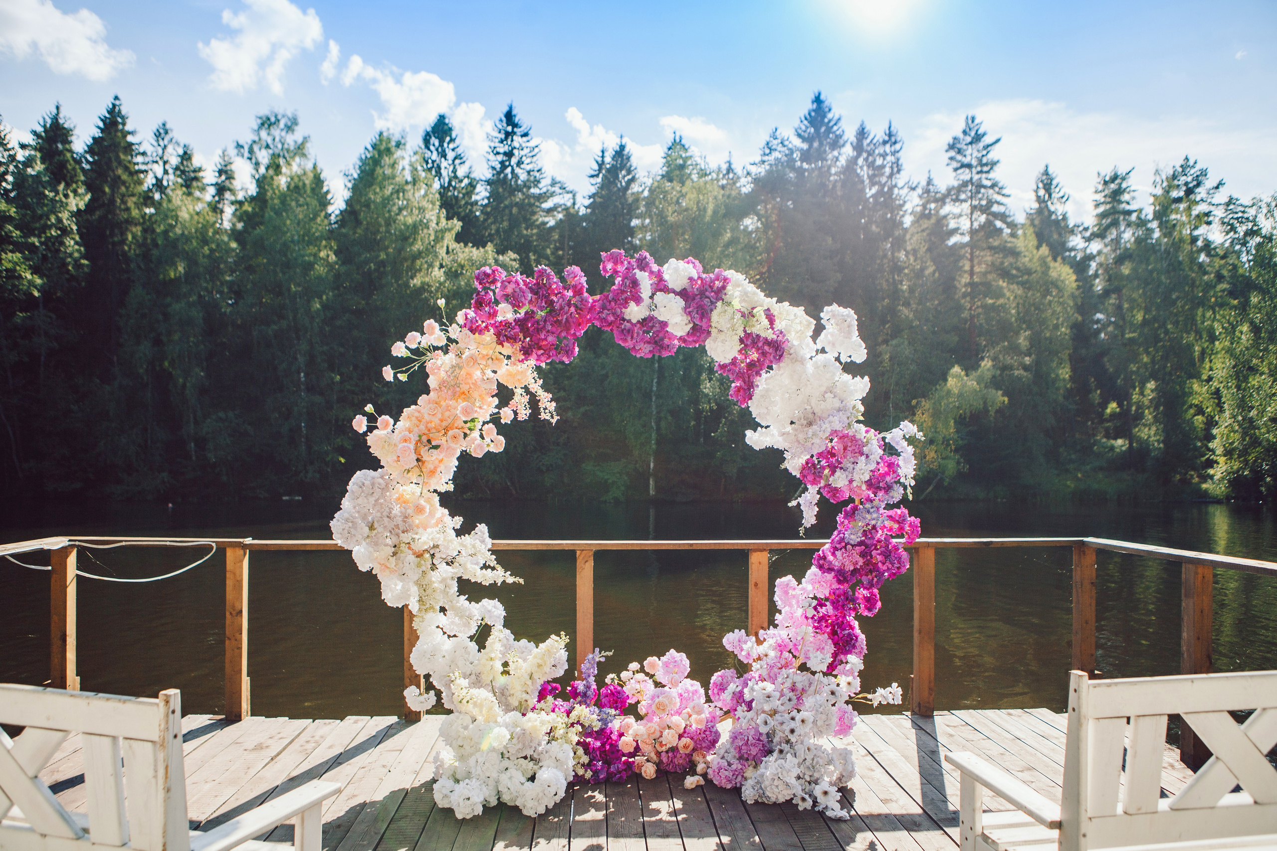 арка с фиолетовыми цветами на выездной регистрации на фоне реки