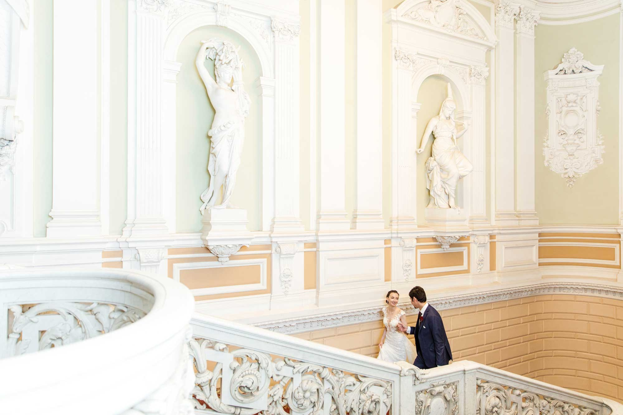 Невеста и жених поднимаются по лестнице Дворца Бракосочетаний №1 в СПб