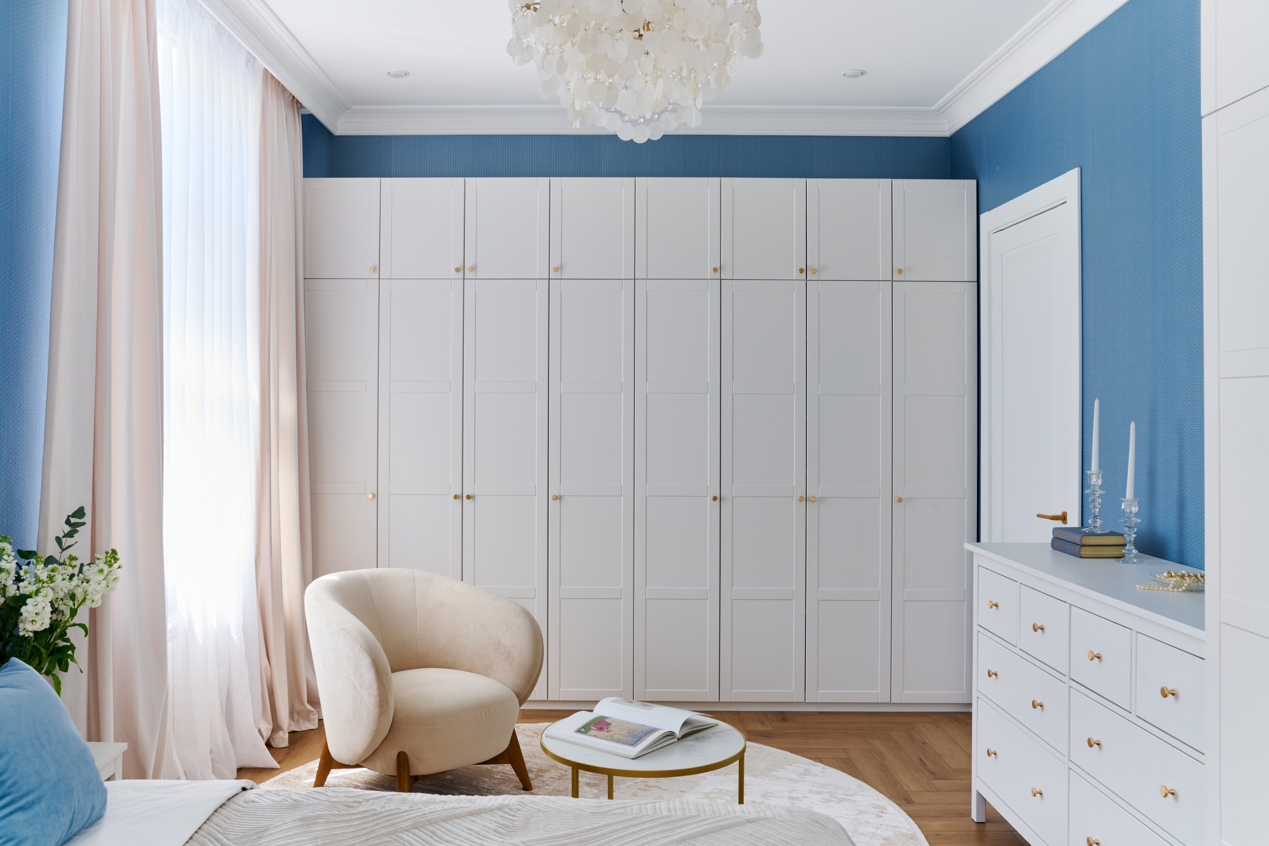 Спальная комната с голубыми стенами, шкафом и креслом