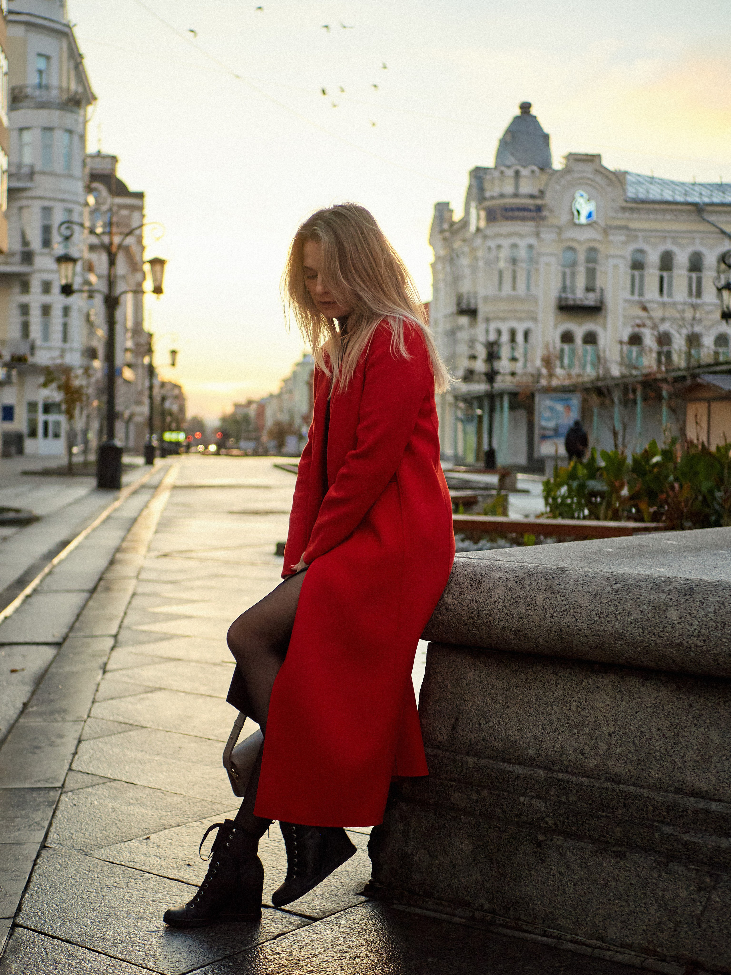 Олеся. Девушка в красном пальто сидит на фонтане