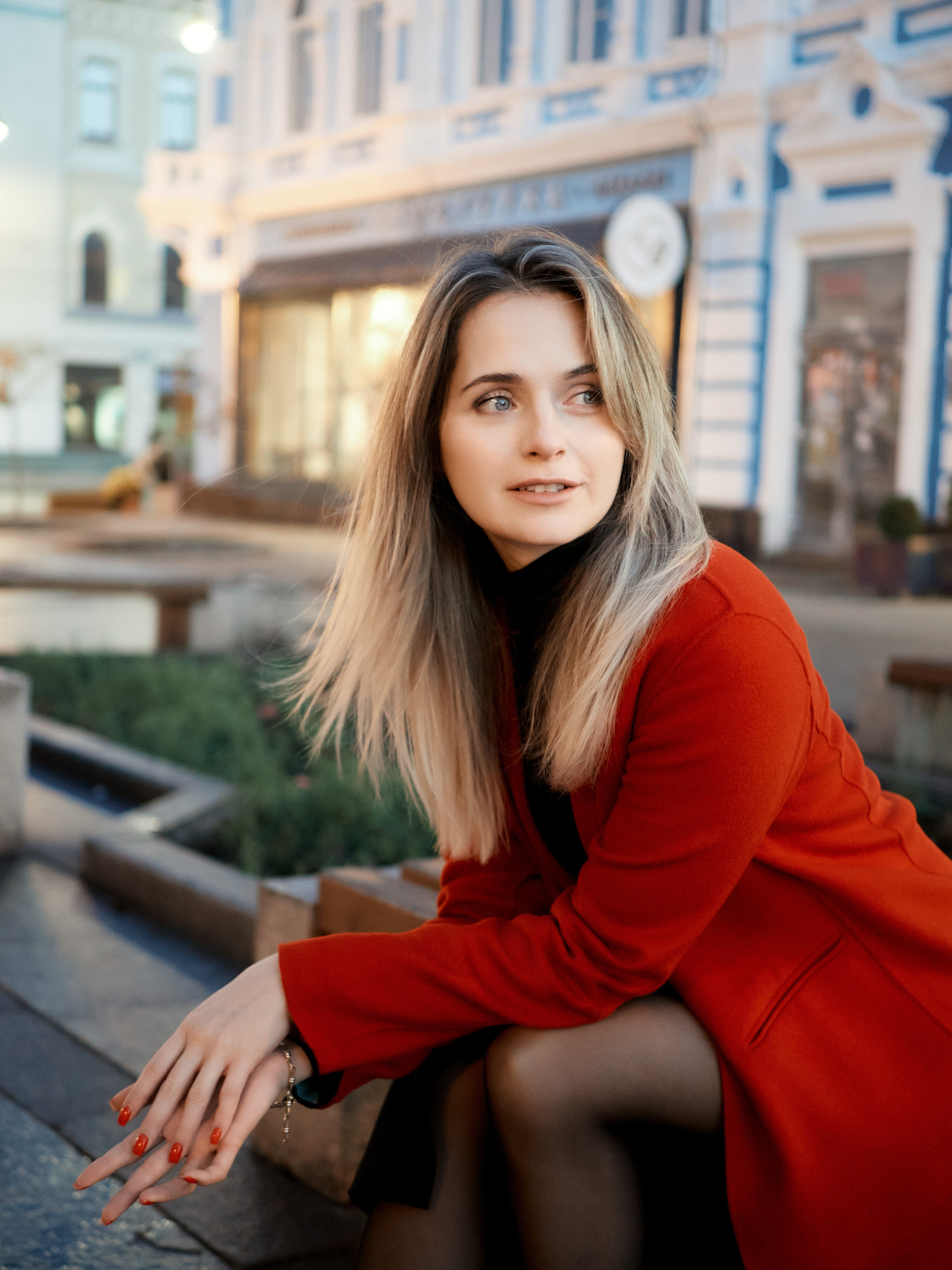 Олеся. Девушка в красном пальто сидит на улице Самары