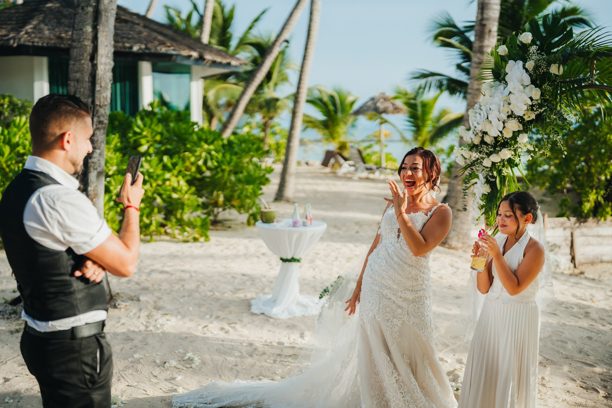 Bride and groom celebrating a beach wedding with their children in Koh Samui, Thailand, surrounded by tropical scenery and ocean views