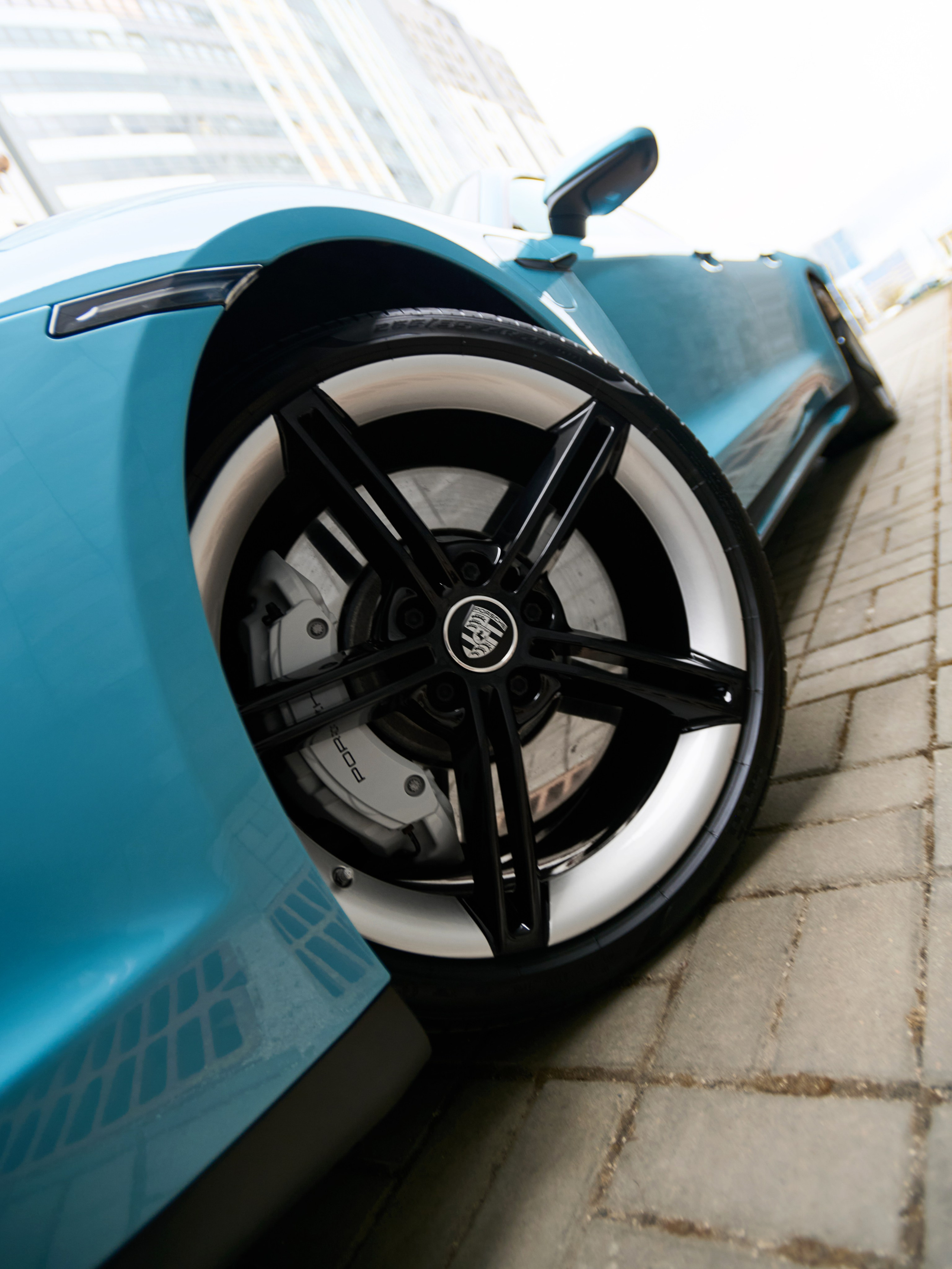 Переднее колесо голубого Porsche Taycan 4S крупным планом