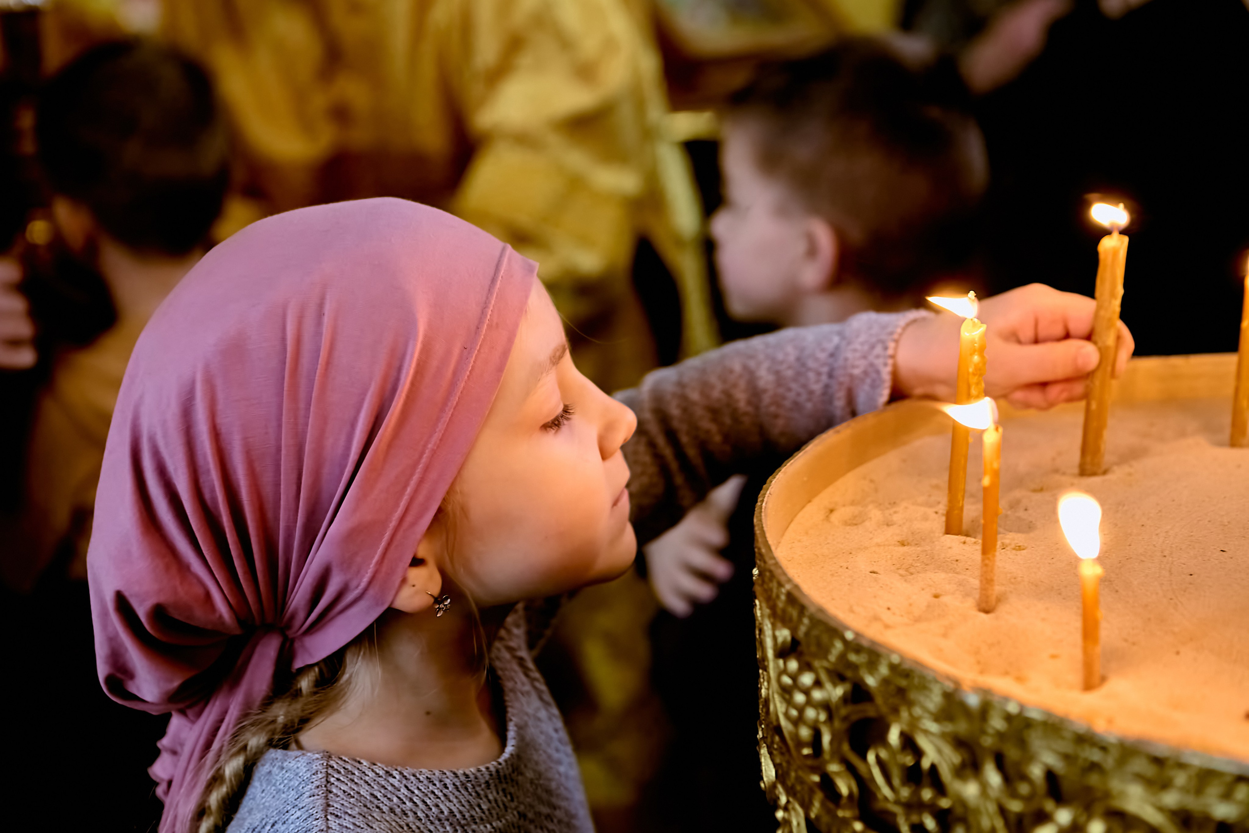 Девочка ставит свечу на подсвечник в храме. г. Дзержинск