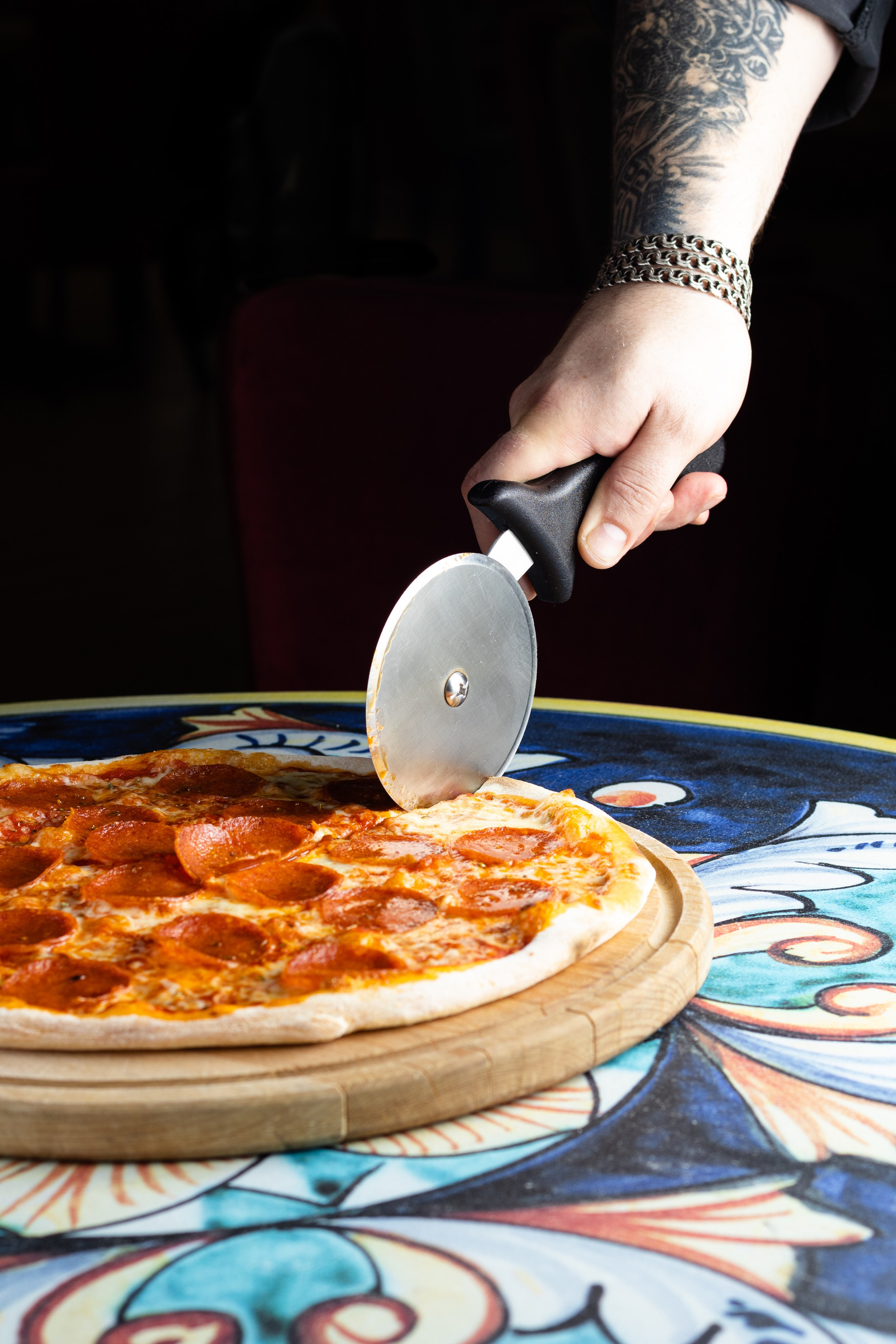 Шеф-повар разрезает пиццу пепперони