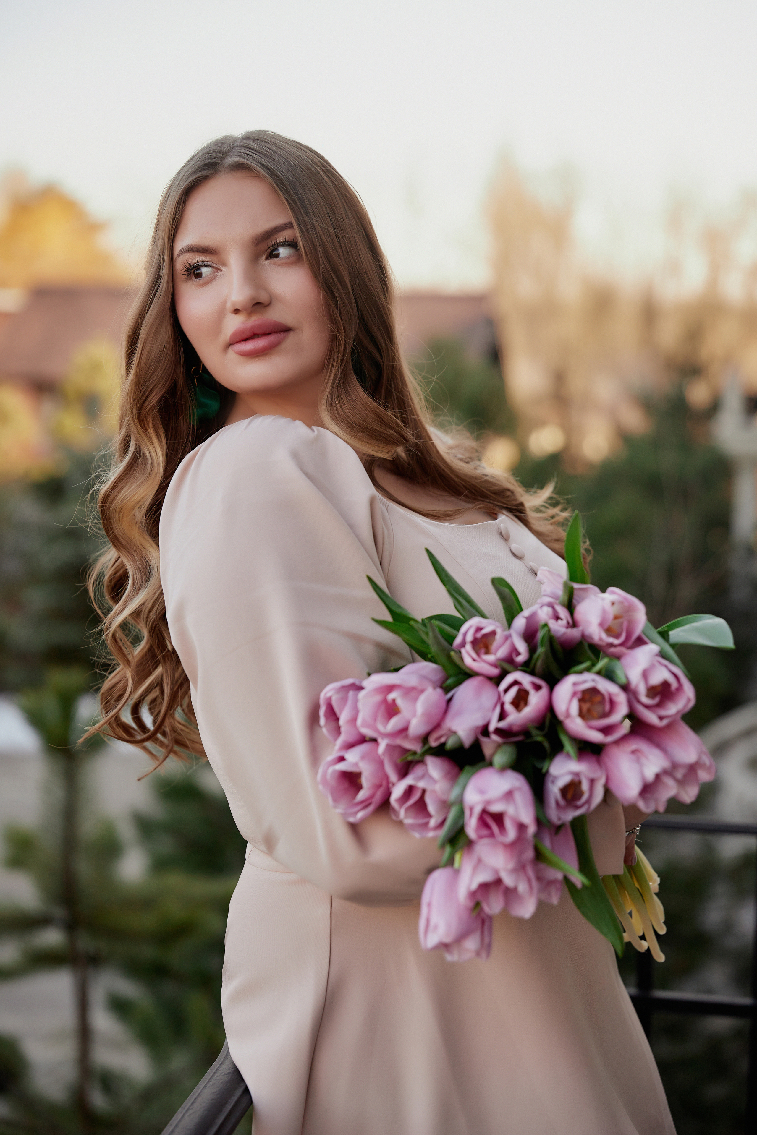 Девушка  с букетом розовых тюльпанов на балконе