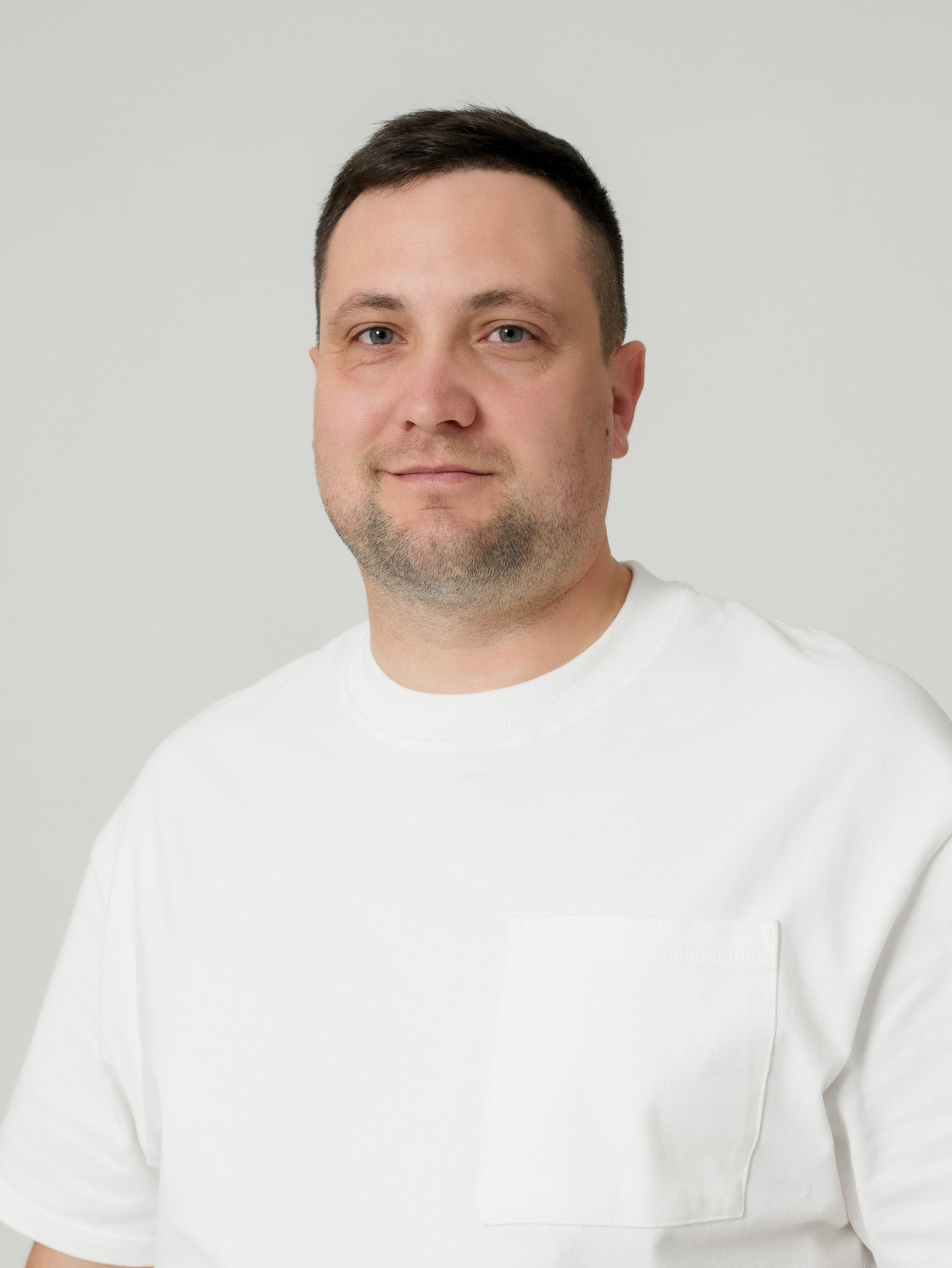 портрет мужчины по грудь в белой футболке на белом фоне