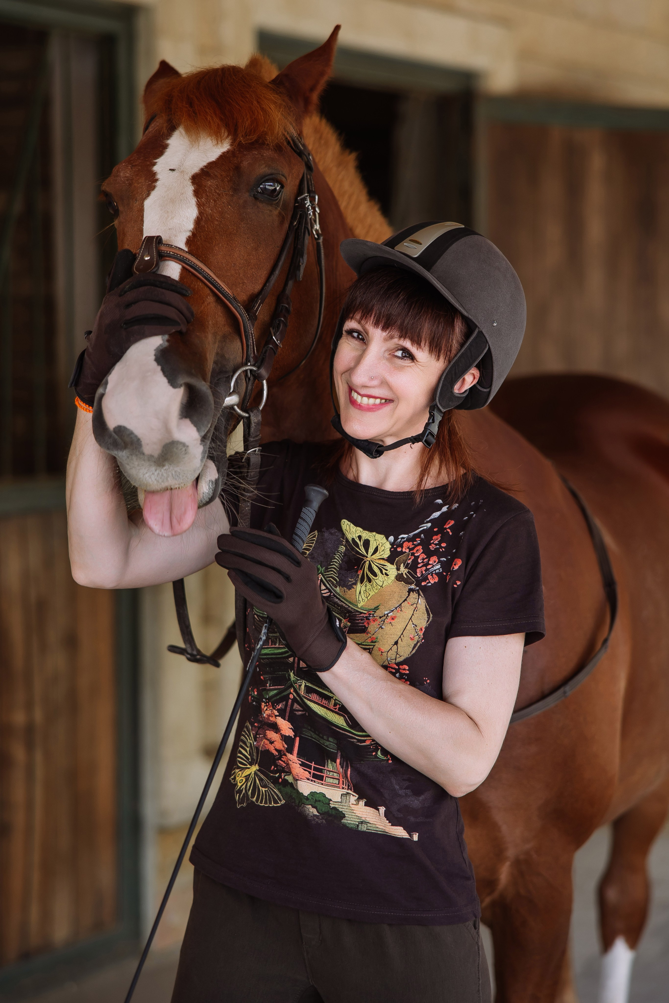 Фотография наездницы с лошадью, показывающей язык