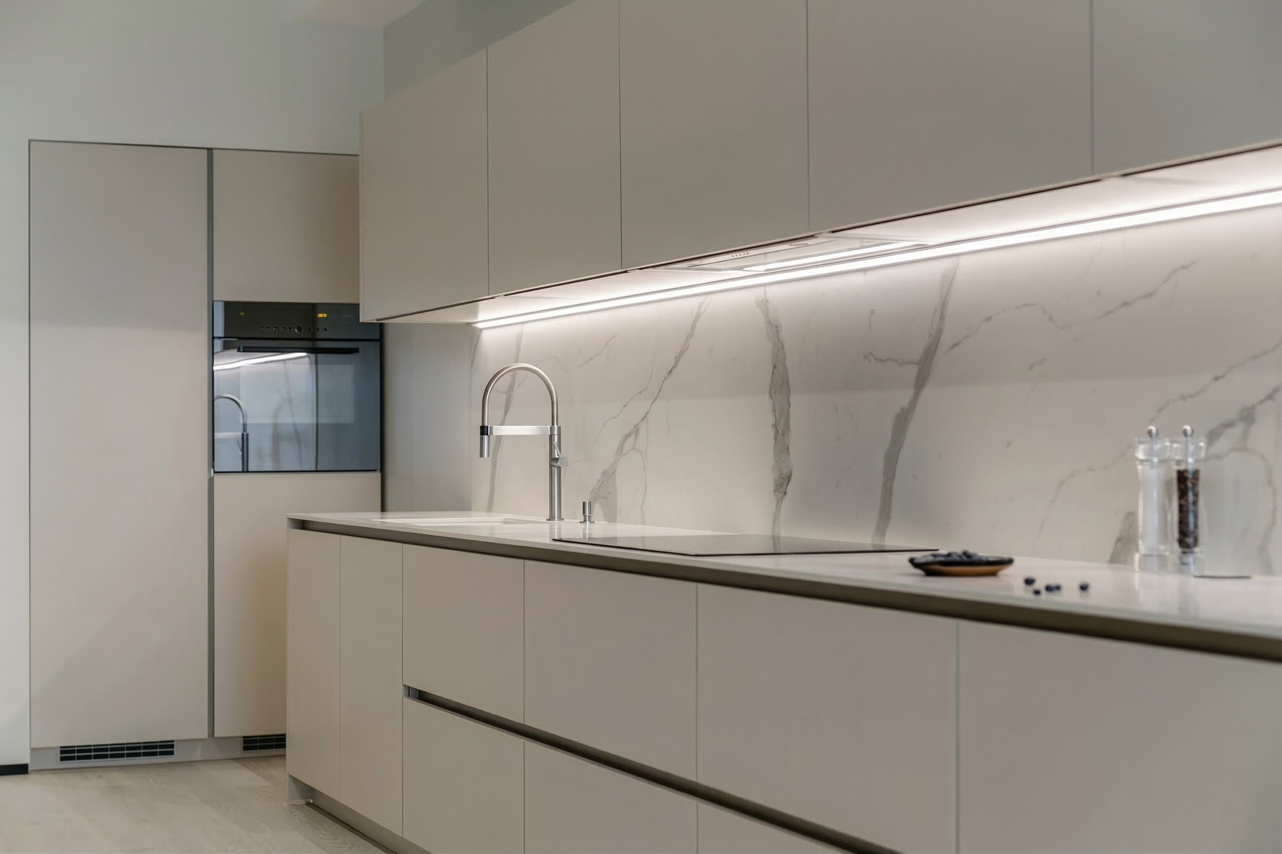 Детали реализации: матовые бежевые фасады кухни, каменная столешница и точные зазоры. Реализованный проект Валерии Котович.