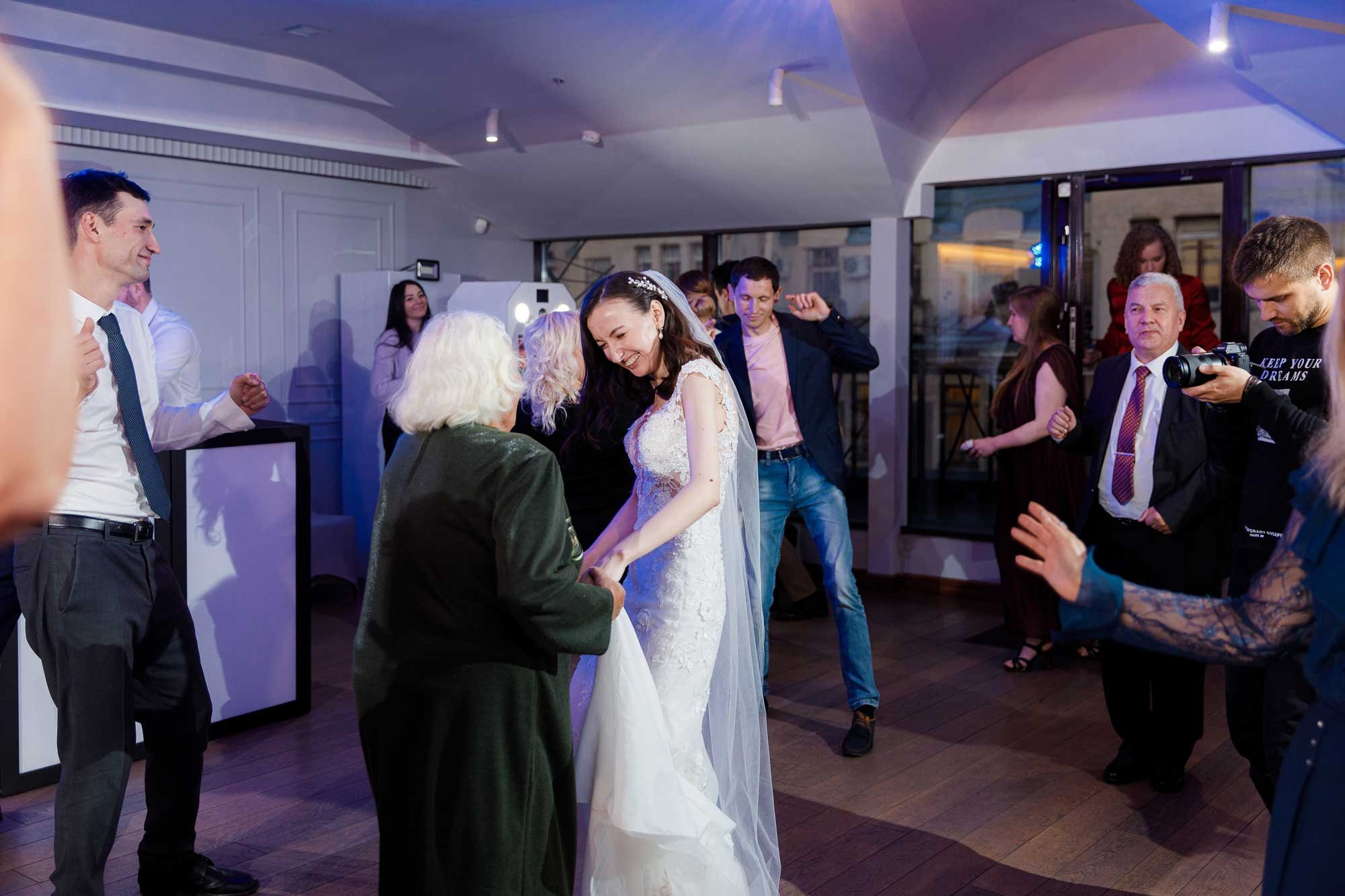 Невеста танцует с бабушкой в ресторане