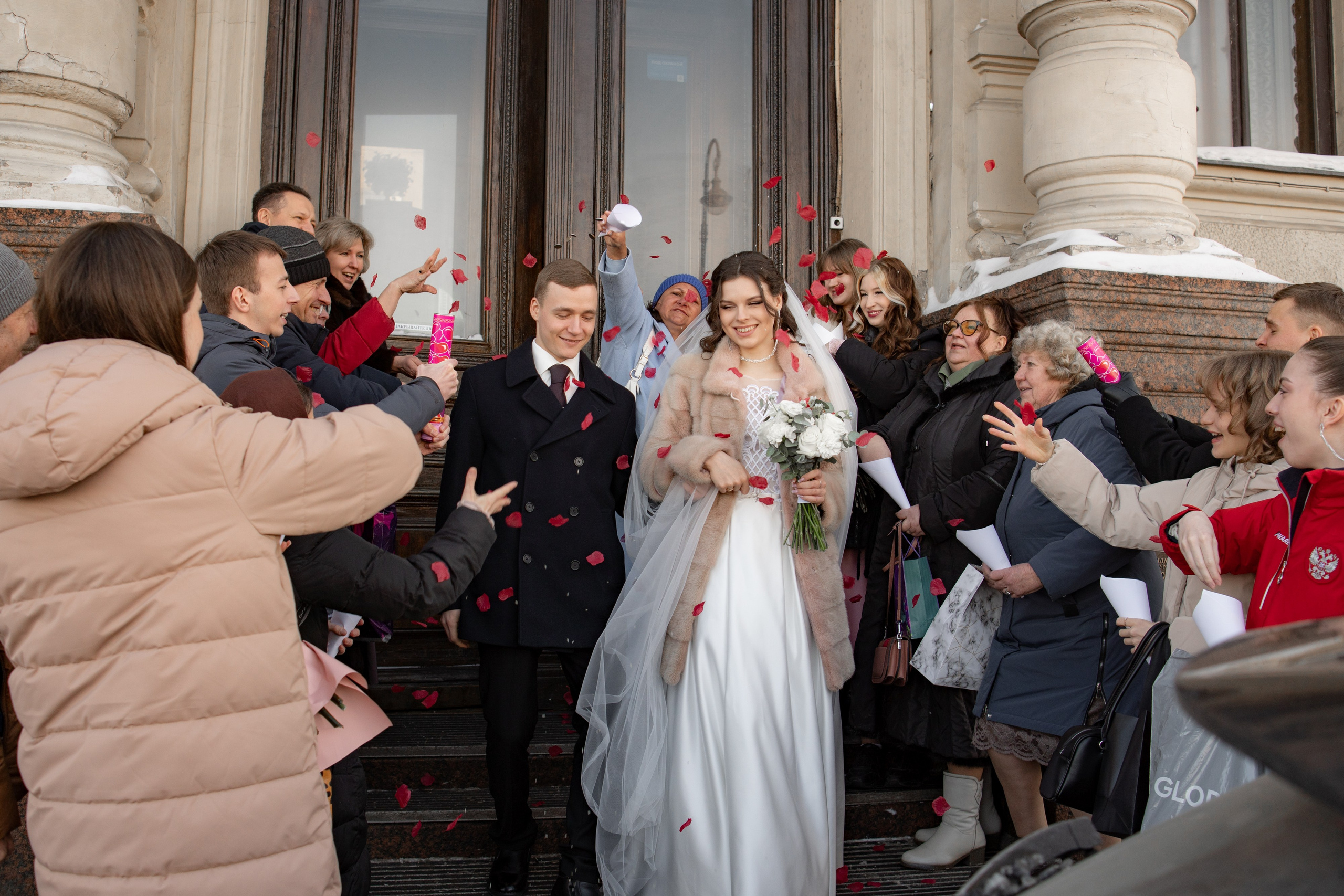 Свадебная фотосессия в Санкт-Петербурге во дворце  бракосочетания №1 на Английской набережной. Невеста и жених выходят из загса, а гости радостно встречают молодых.