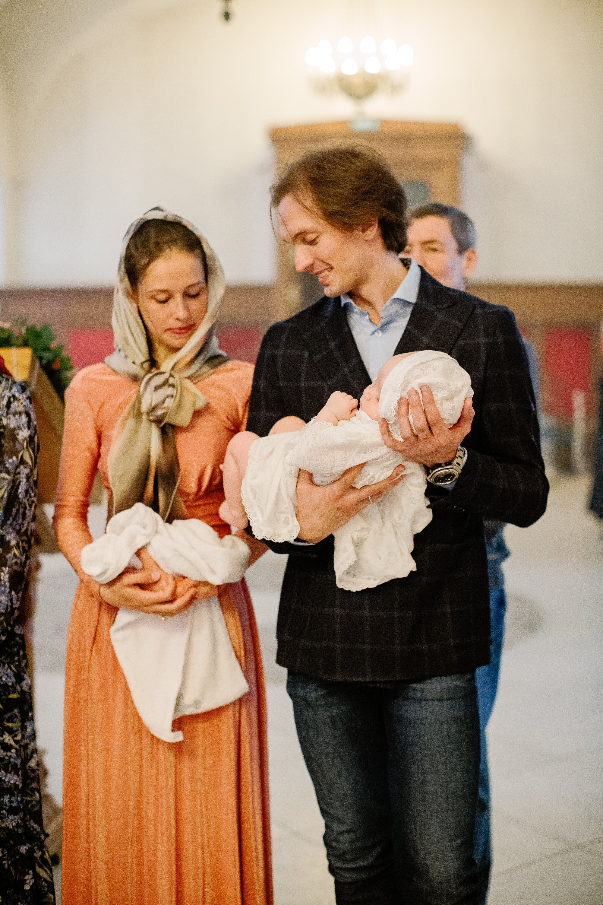 Папа держит на руках дочку во время крещения в одном из храмов Москвы.