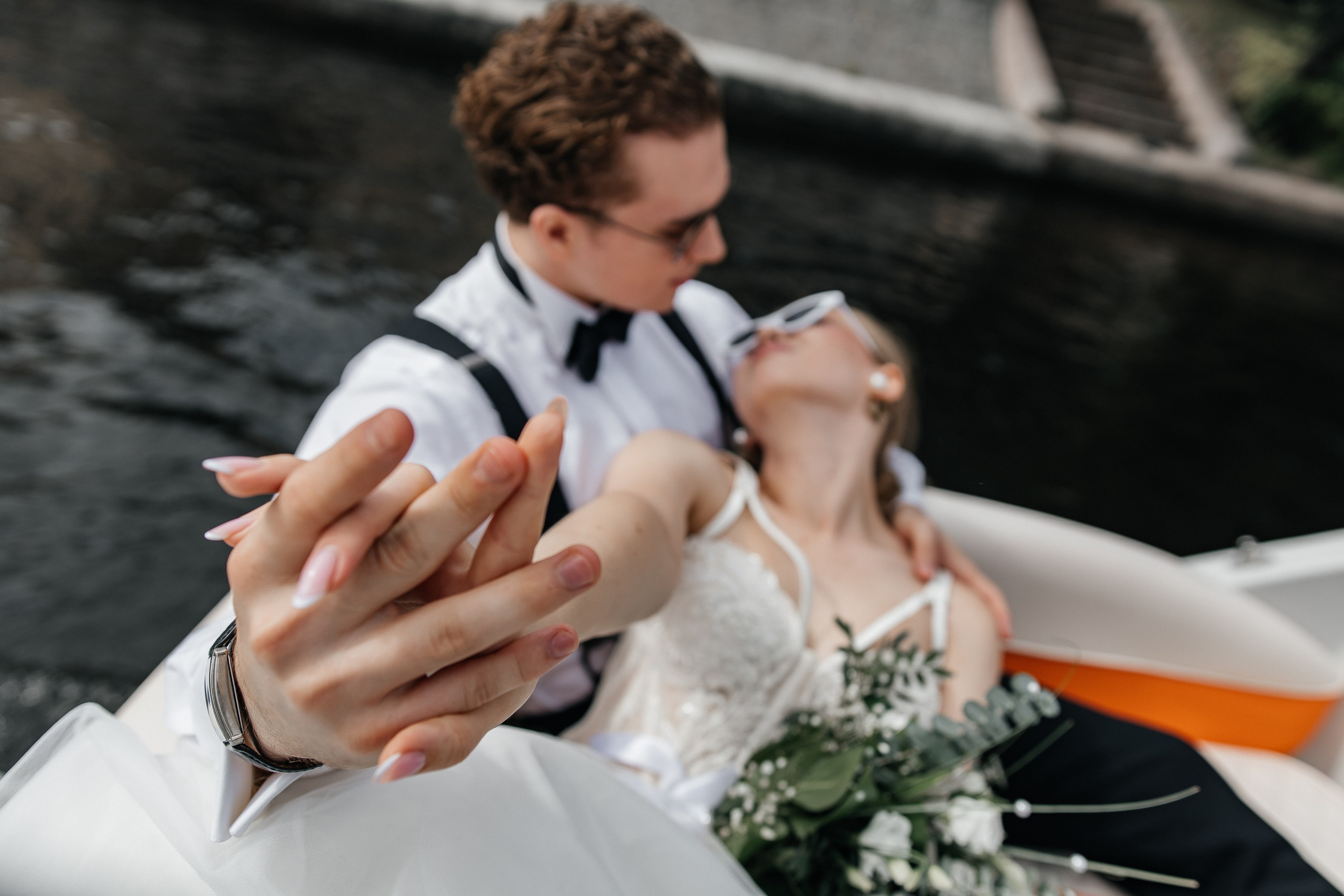 Жених и невеста страстно держатся за руки, нежно глядя друг другу в глаза. Любовь и счастье в их взгляде.спбфотогрф