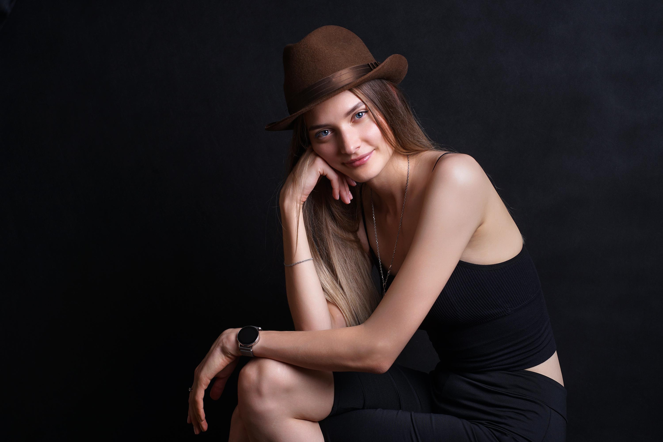 Портрет девушки в щляпе на чёрном фоне