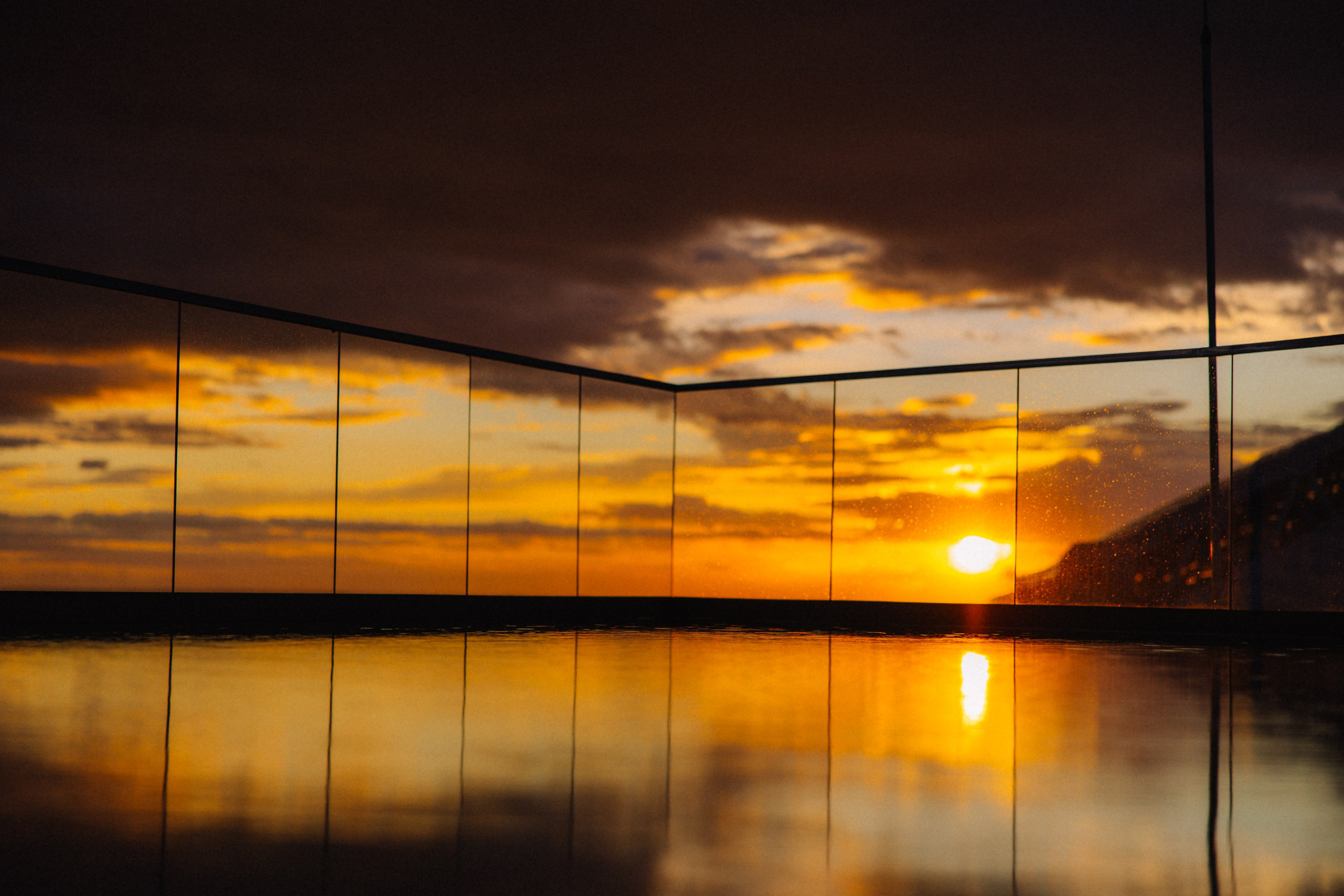 Закат: Отражение оранжевого заката в панорамном остеклении террасы.