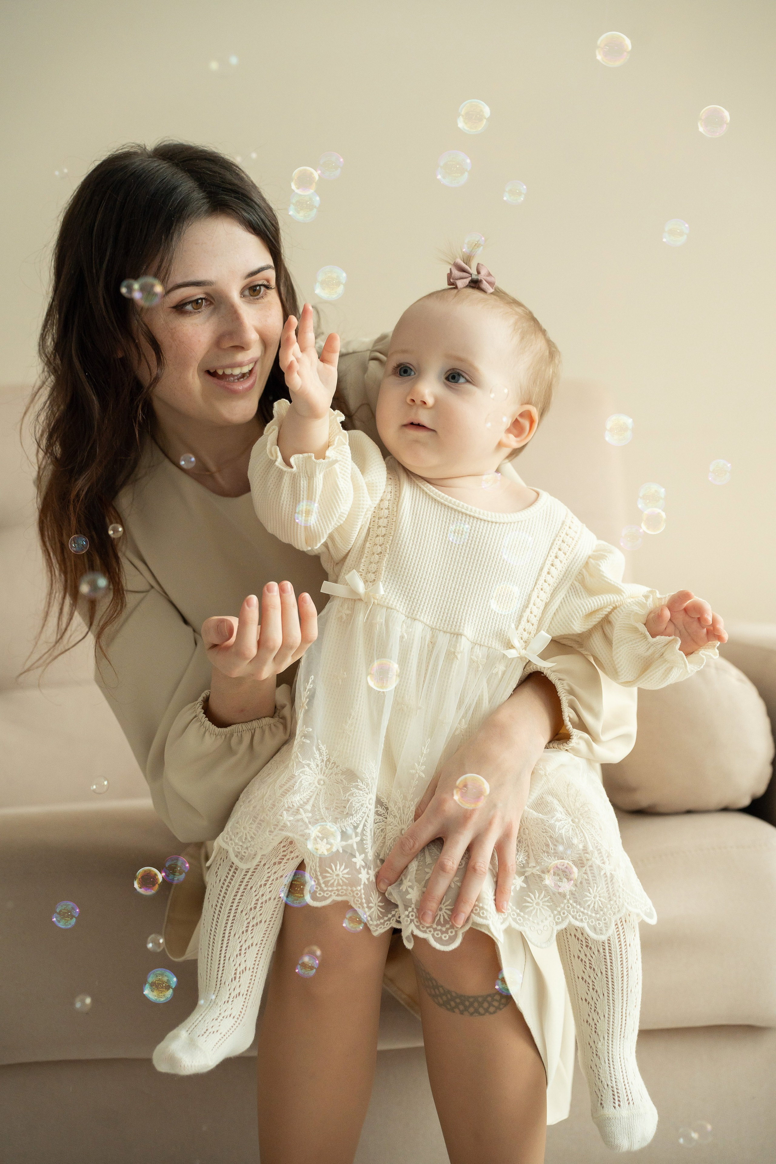 Мама с малышом ловят мыльные пузыри на фотосессии на годик.