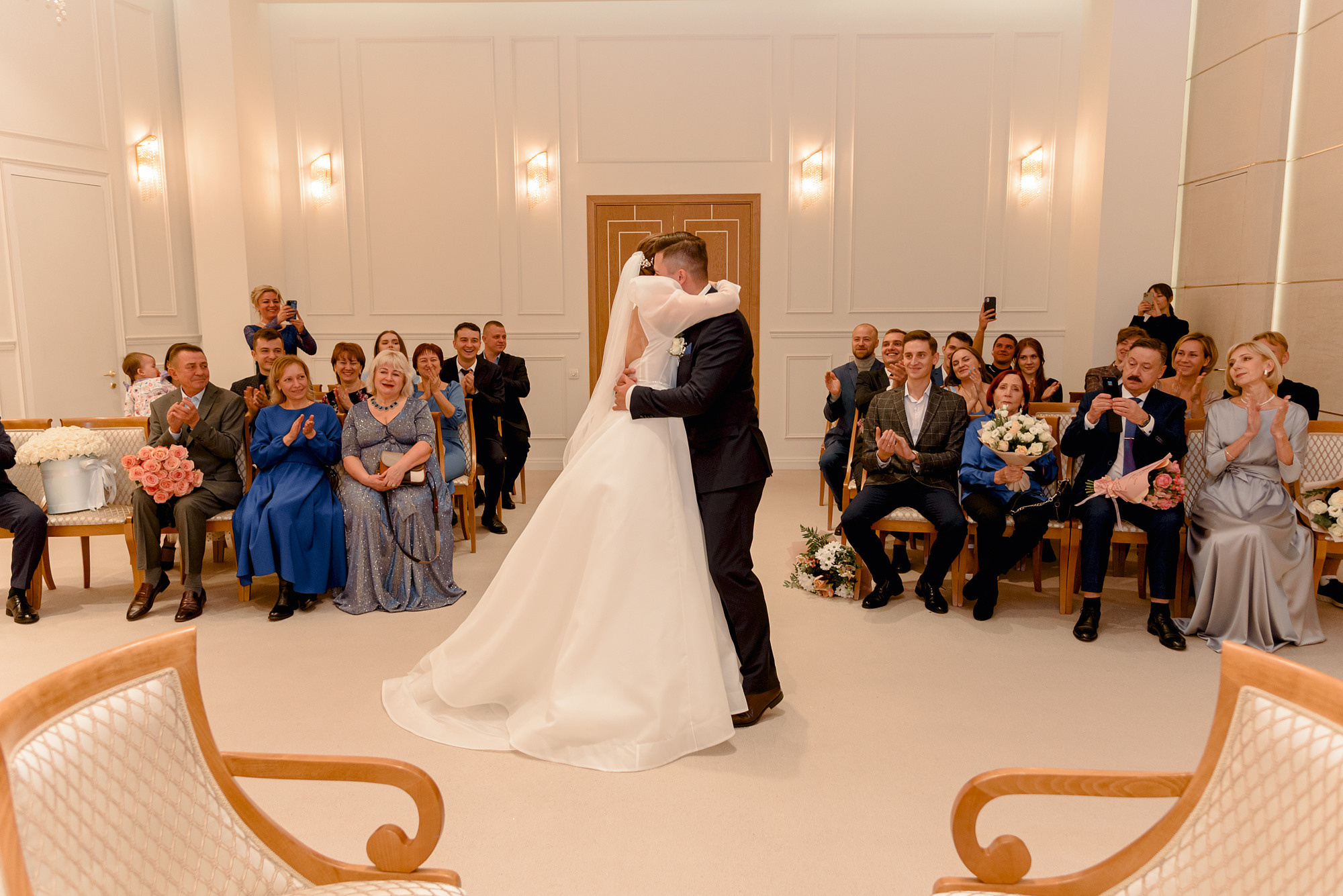 жених и невеста обнимаются в загсе 