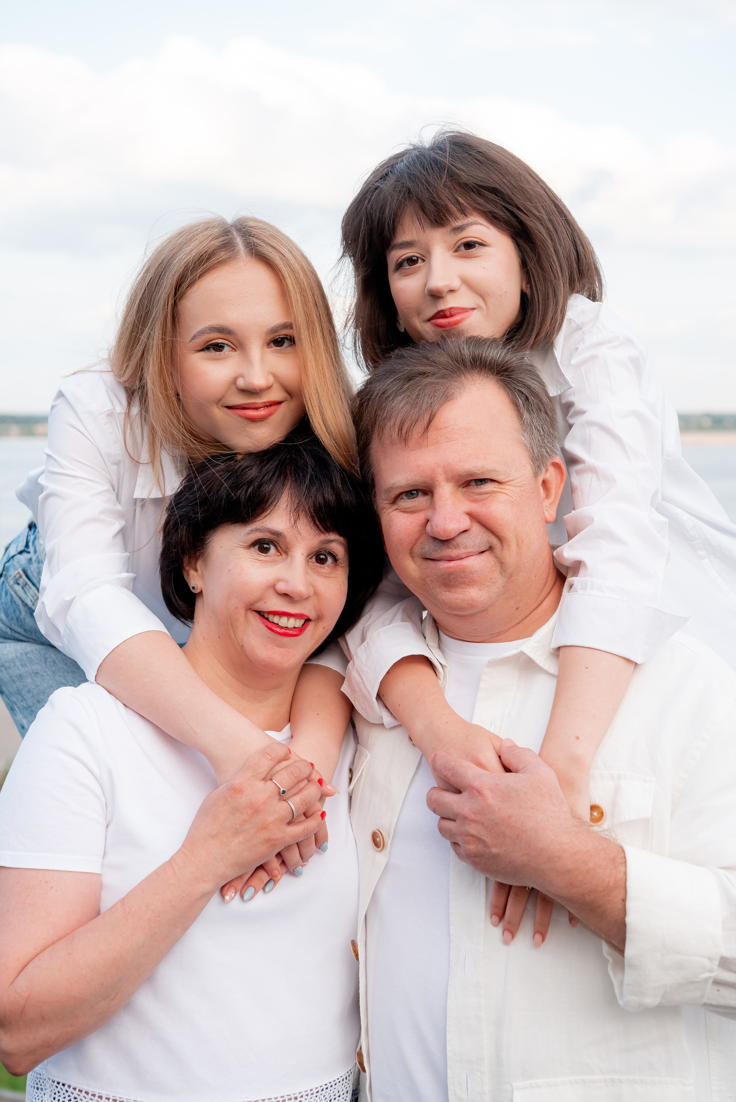 Постановочной семейный портрет родителей и две взрослых дочки на улице