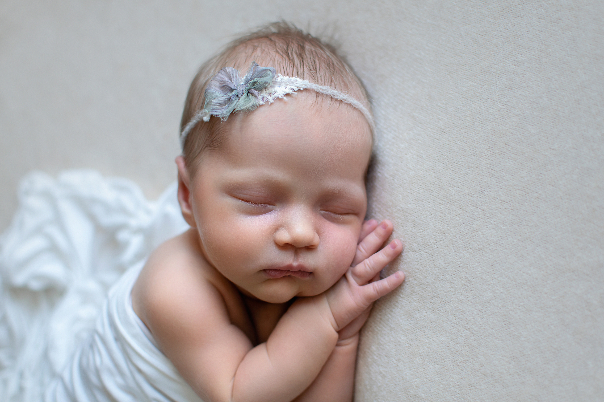 Портрет новорожденной девочки спящей на боку ручки под щечкой