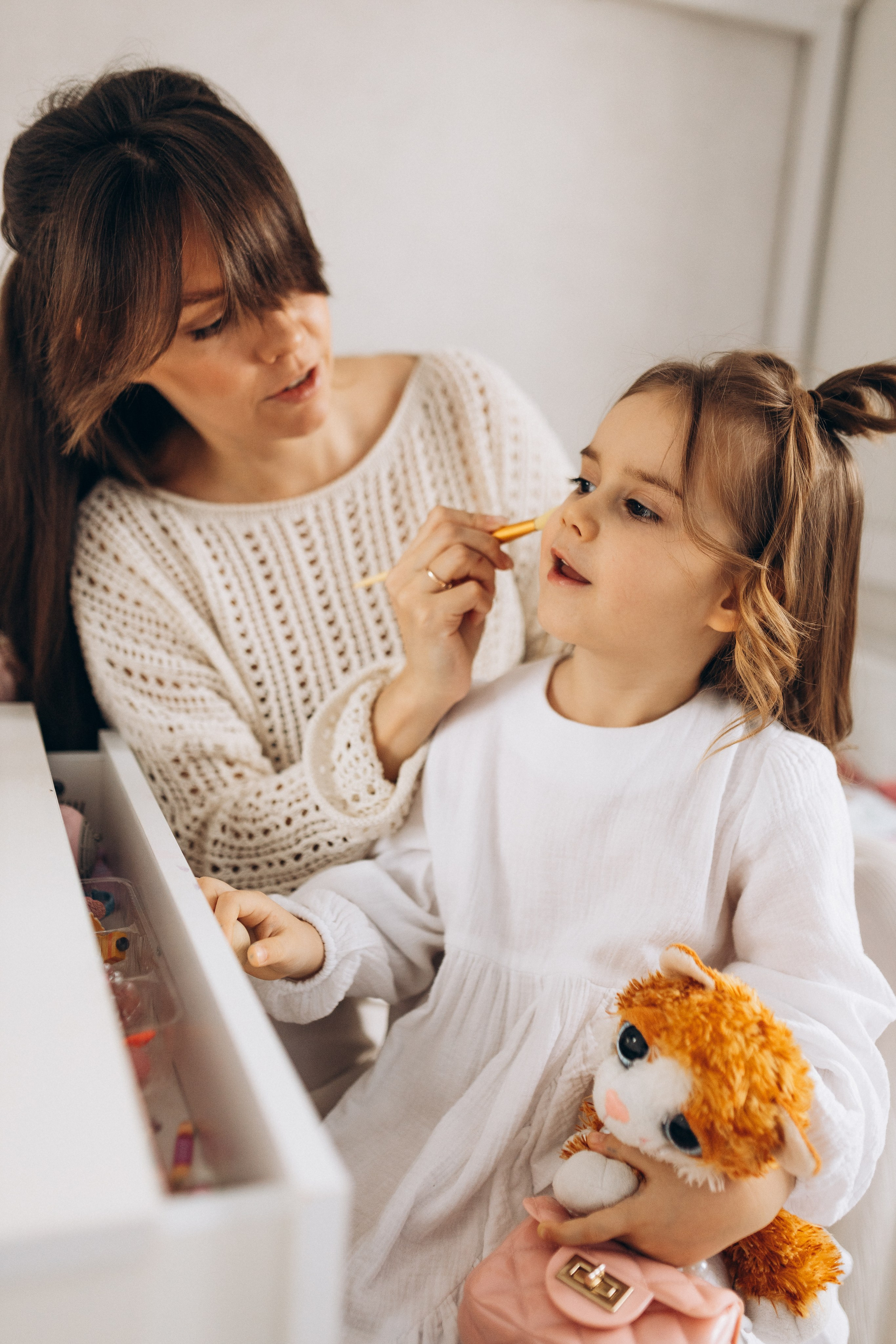 мама делает макияж маленькой дочке