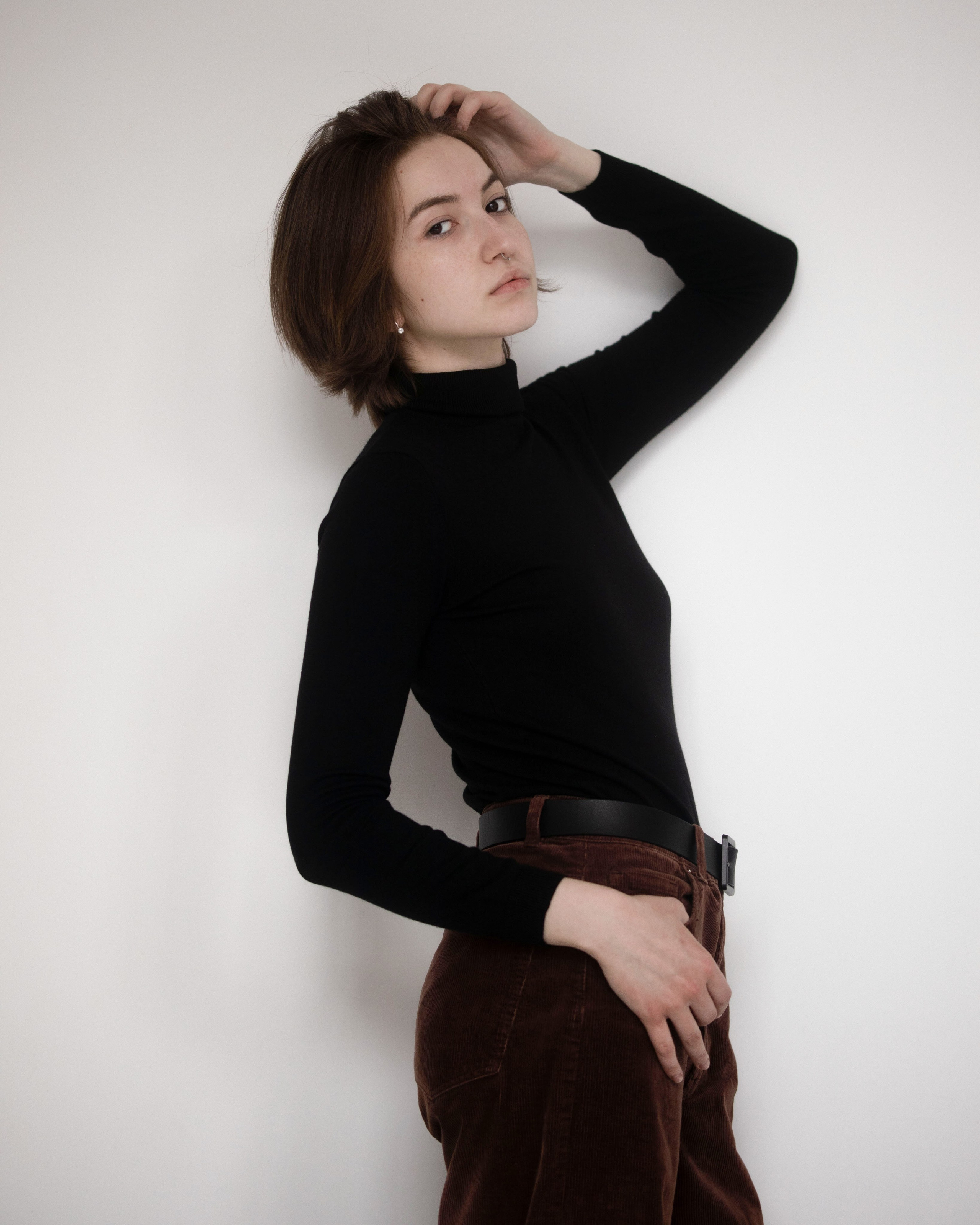 портрет в черном на фоне стены в студии