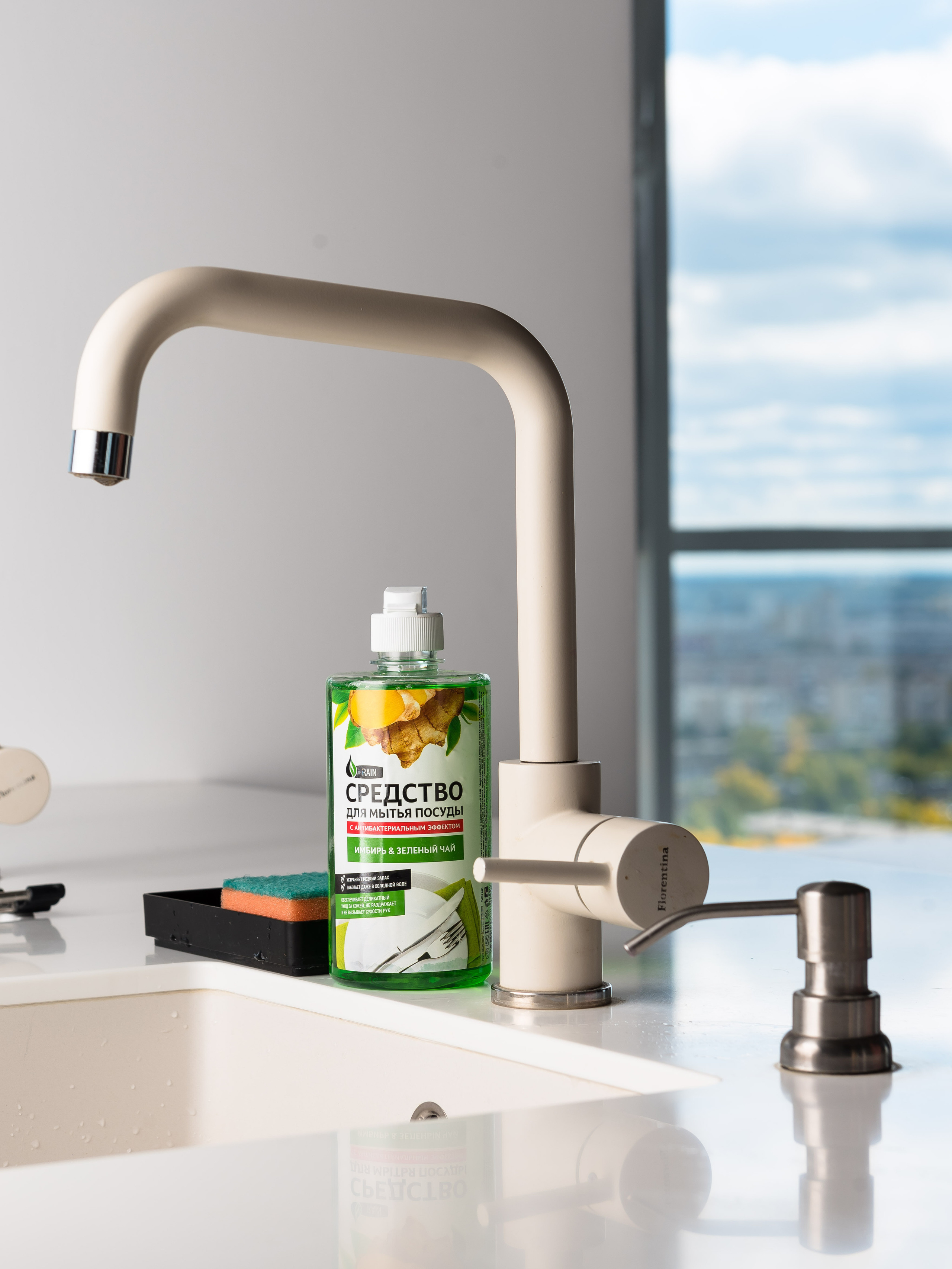 Средство для мытья посуды на раковине на фоне окна с видом на небо
