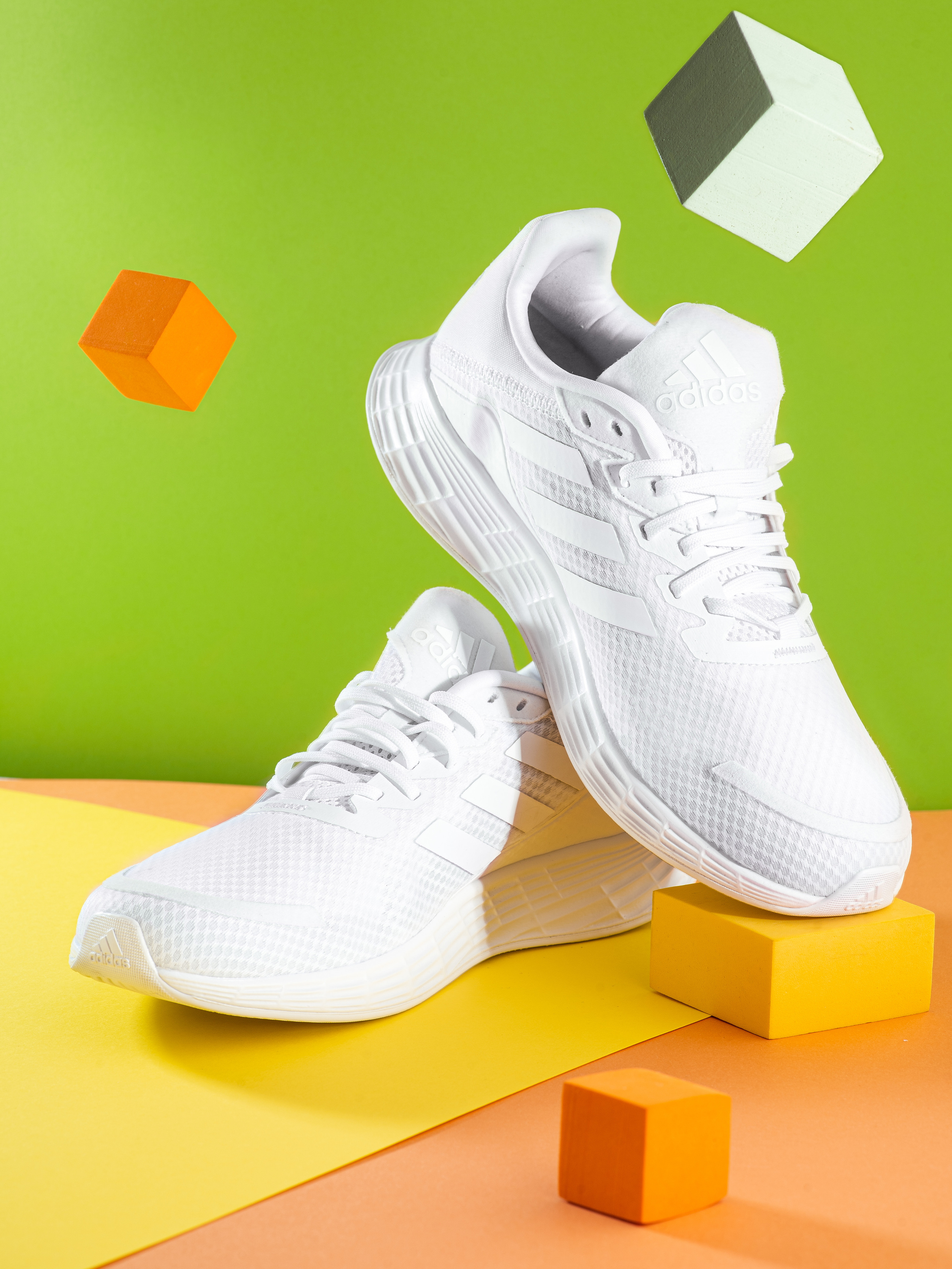 Реклама кросовок на ярком фоне с летящими кубами