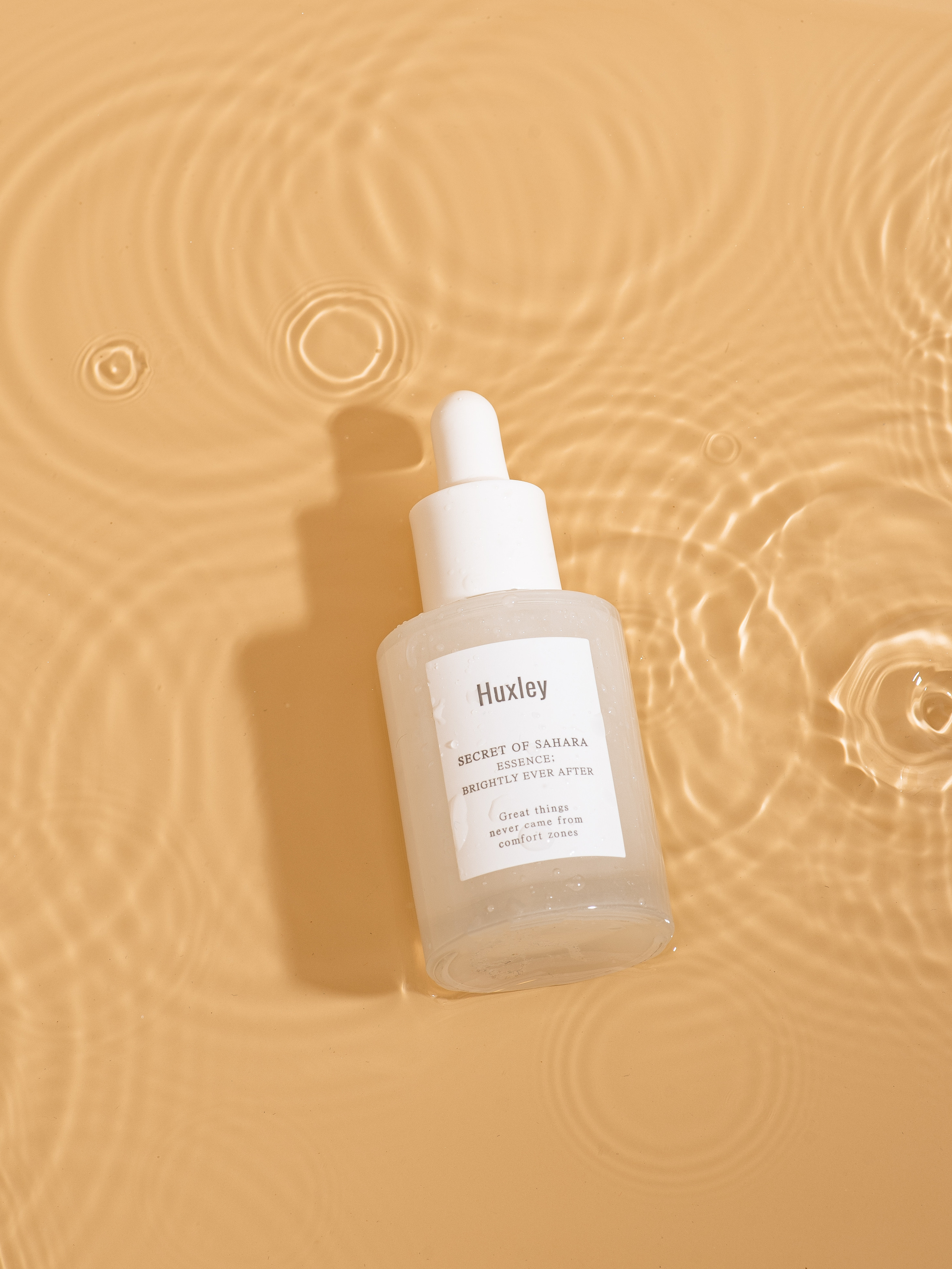 Сыворотка для лица в каплях воды на желтом фоне, продающий контент