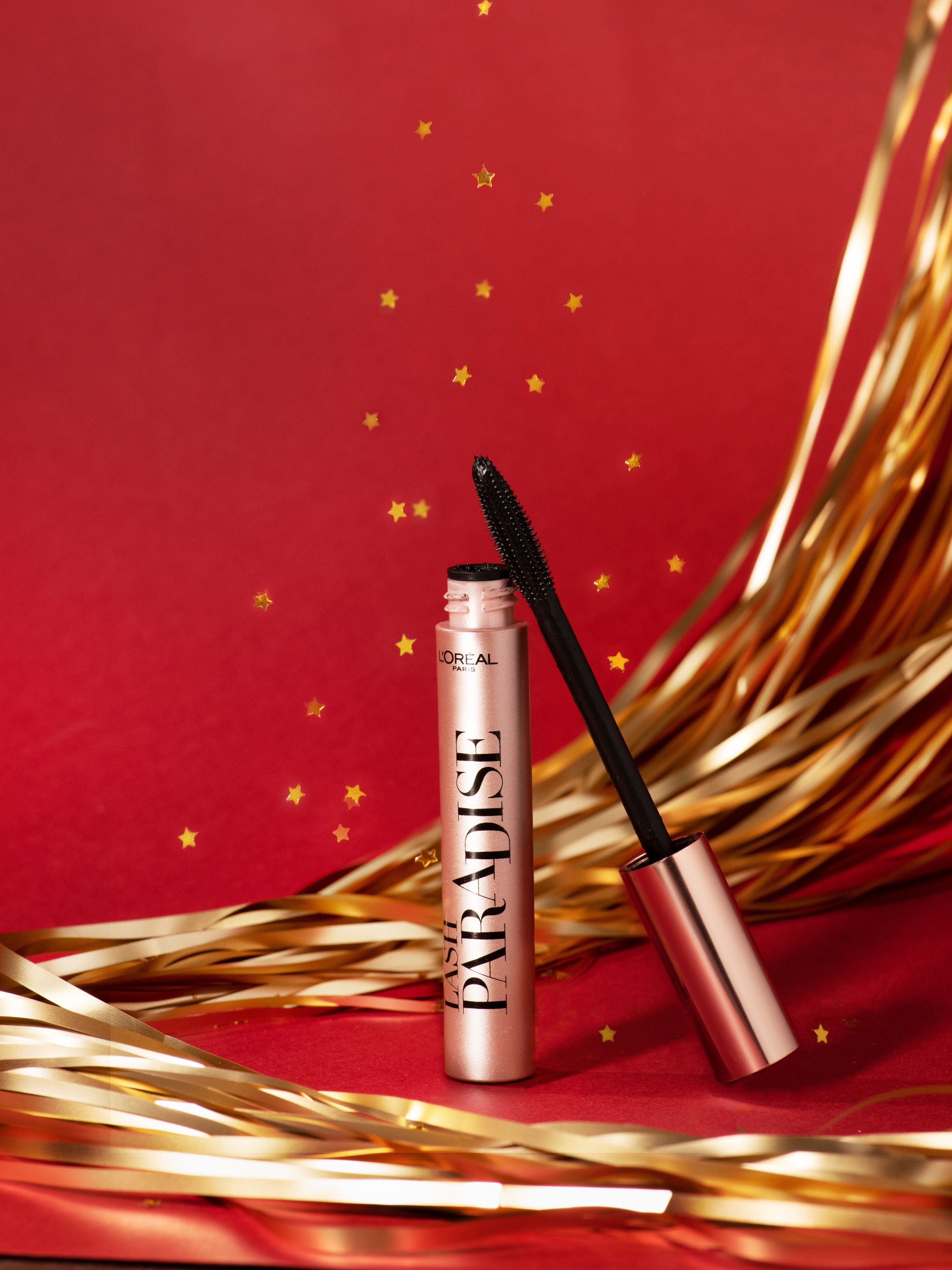 Новогодняя съемка туши на красном фоне с летящими звездами и дождиком