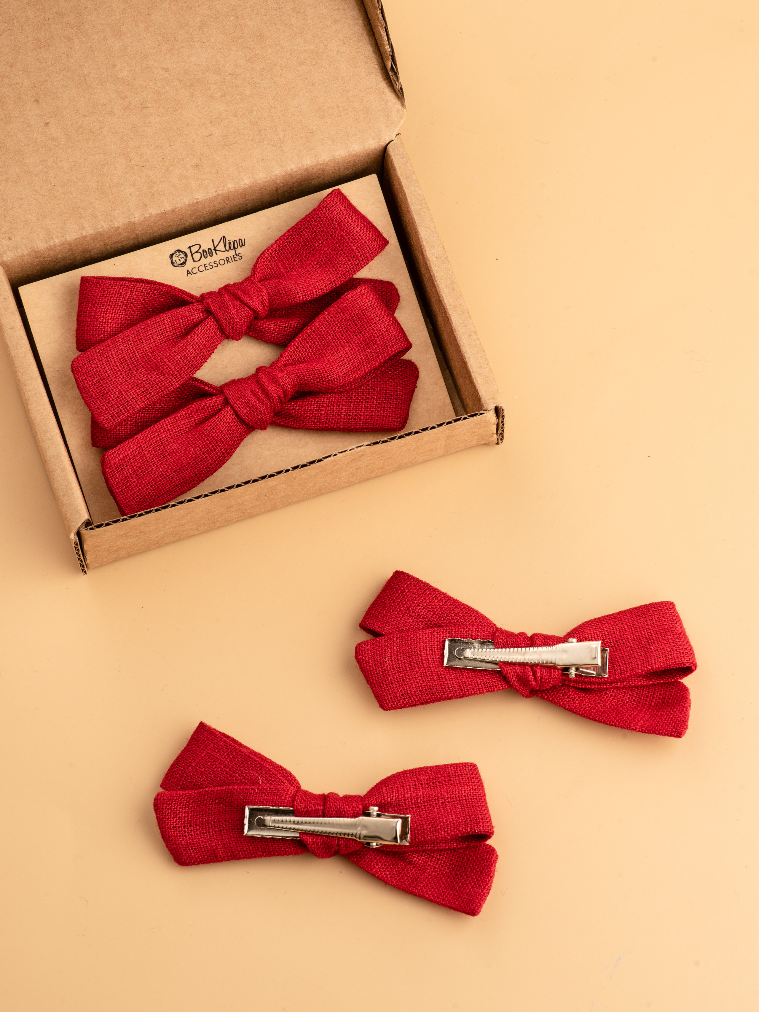 Бантики красные в коробке на бежевом фоне с металлическими застежками 
